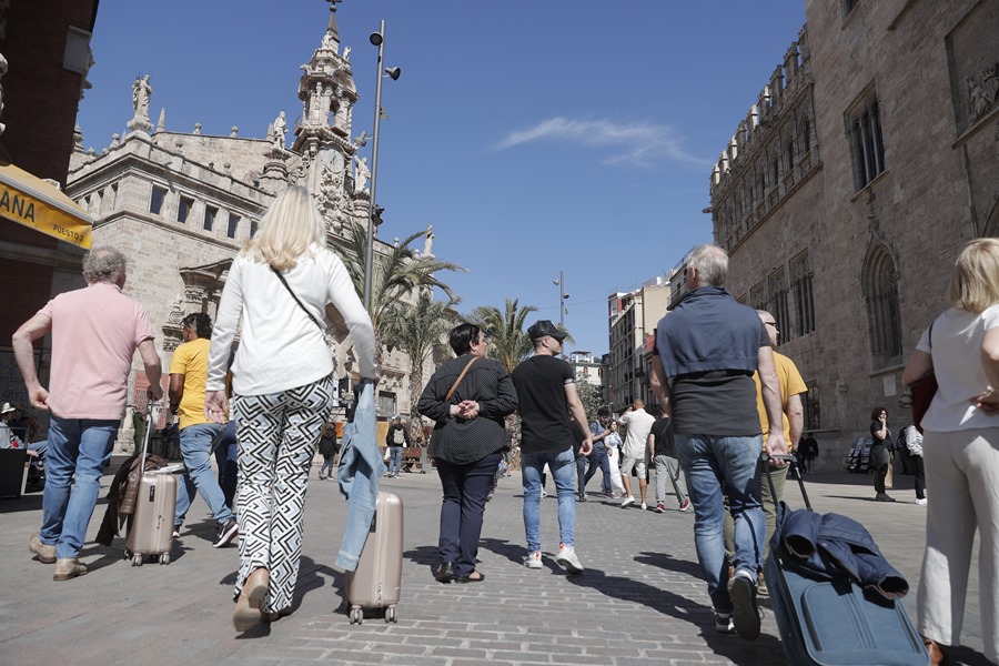 Turistas con maletas en el entorno de la Lonja y el Mercado Central de Valencia