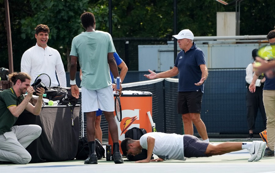 El tenista español Carlos Alcaraz (abajo) "castigado" con una ronda de flexiones tras perder una pachanga con el jugador francés Gael Monfils.
