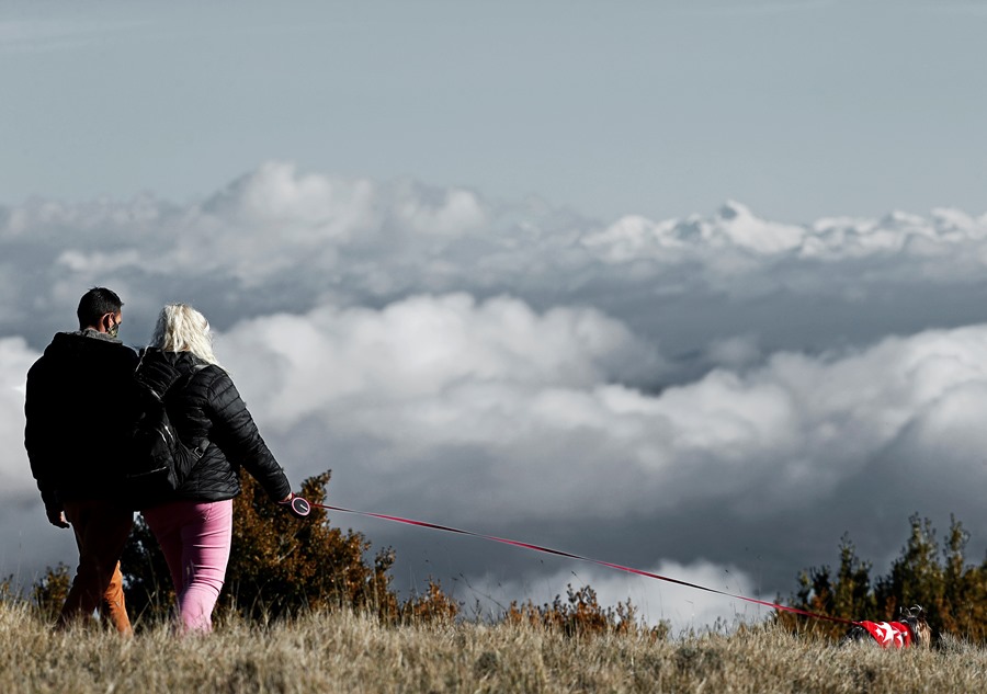 Una pareja pasea junto a su perro por el alto de El Perdón (Pamplona).