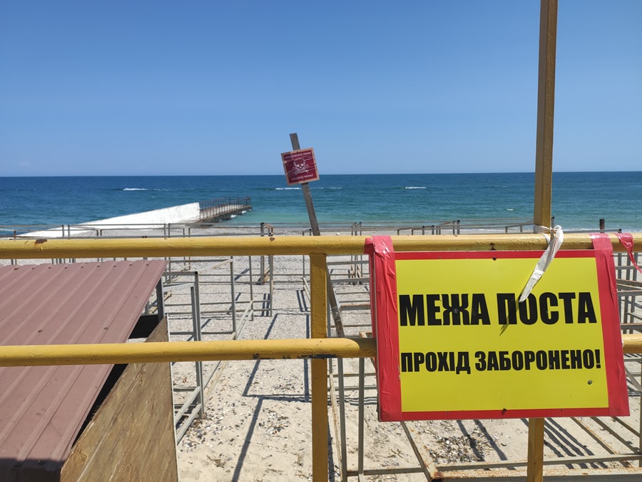 Un cartel avisa del peligro de minas en la entrada de una playa de Odesa, que ve su economía sufrir debido a la invasión rusa.