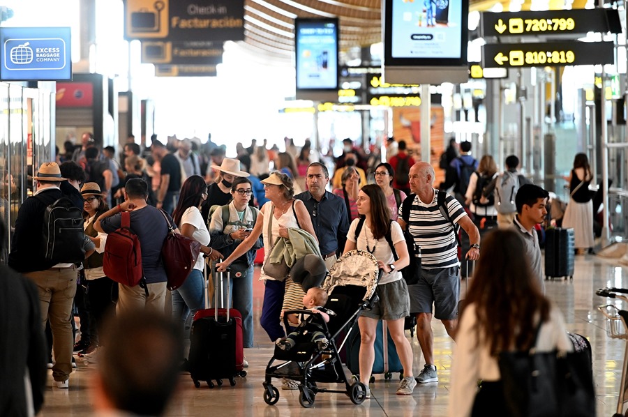 Decenas de personas hacen cola para facturar el equipaje en el Aeropuerto de Barajas de Madrid.