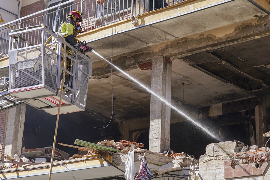 Efectivos de bomberos refrescan la zona mientras realizan labores de limpieza y desescombro en el edificio de la calle Goya en Valladolid,