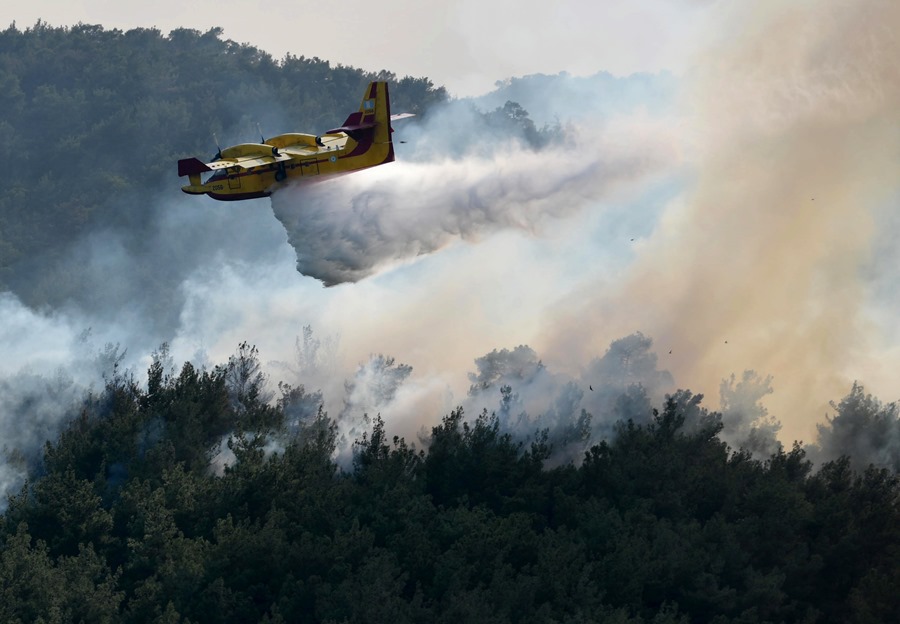 Un avión de extinción de incendios opera durante un incendio forestal en el bosque de Dadia, Tracia
