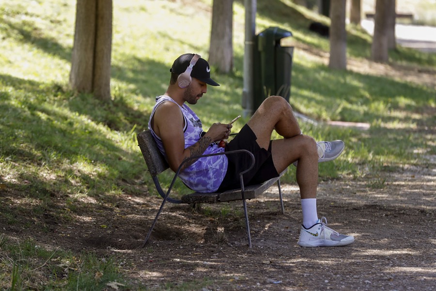 Un hombre descansa en la sombra de un parque en Madrid