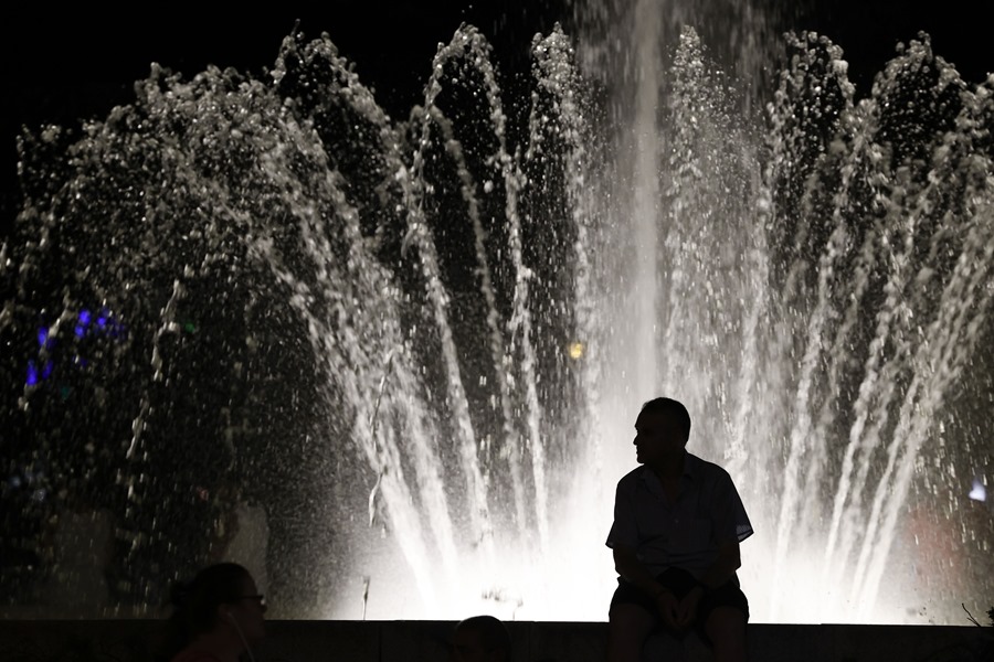 Una persona sentada junto a una fuente en el distrito de Carabanchel.