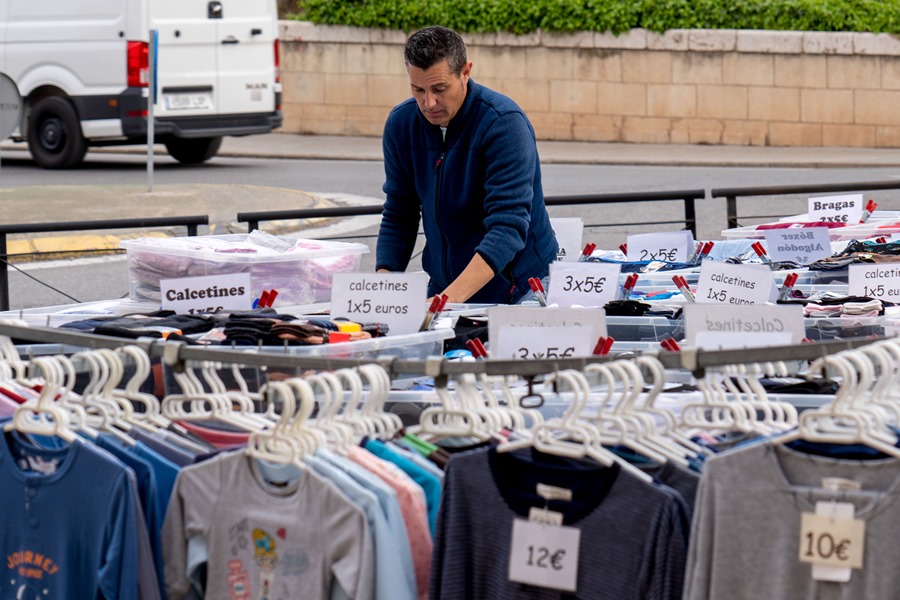 Un trabajador coloca un puesto de ropa en un mercadillo de Teruel.