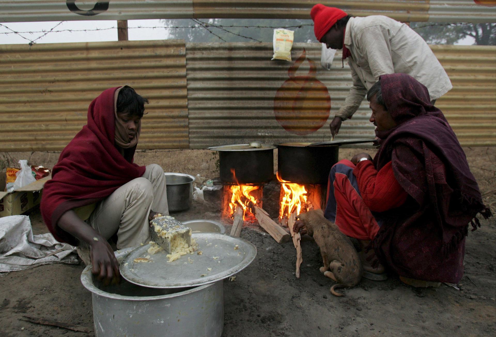 A file photo from Gurgaon, a suburb of New Delhi, India, shows Indian men trying to warm up during a cold and cloudy morning  on January 7, 2008. Religious violence in Gurgaon and a nearby region has claimed five lives. EFE/ MONEY SHARRMA