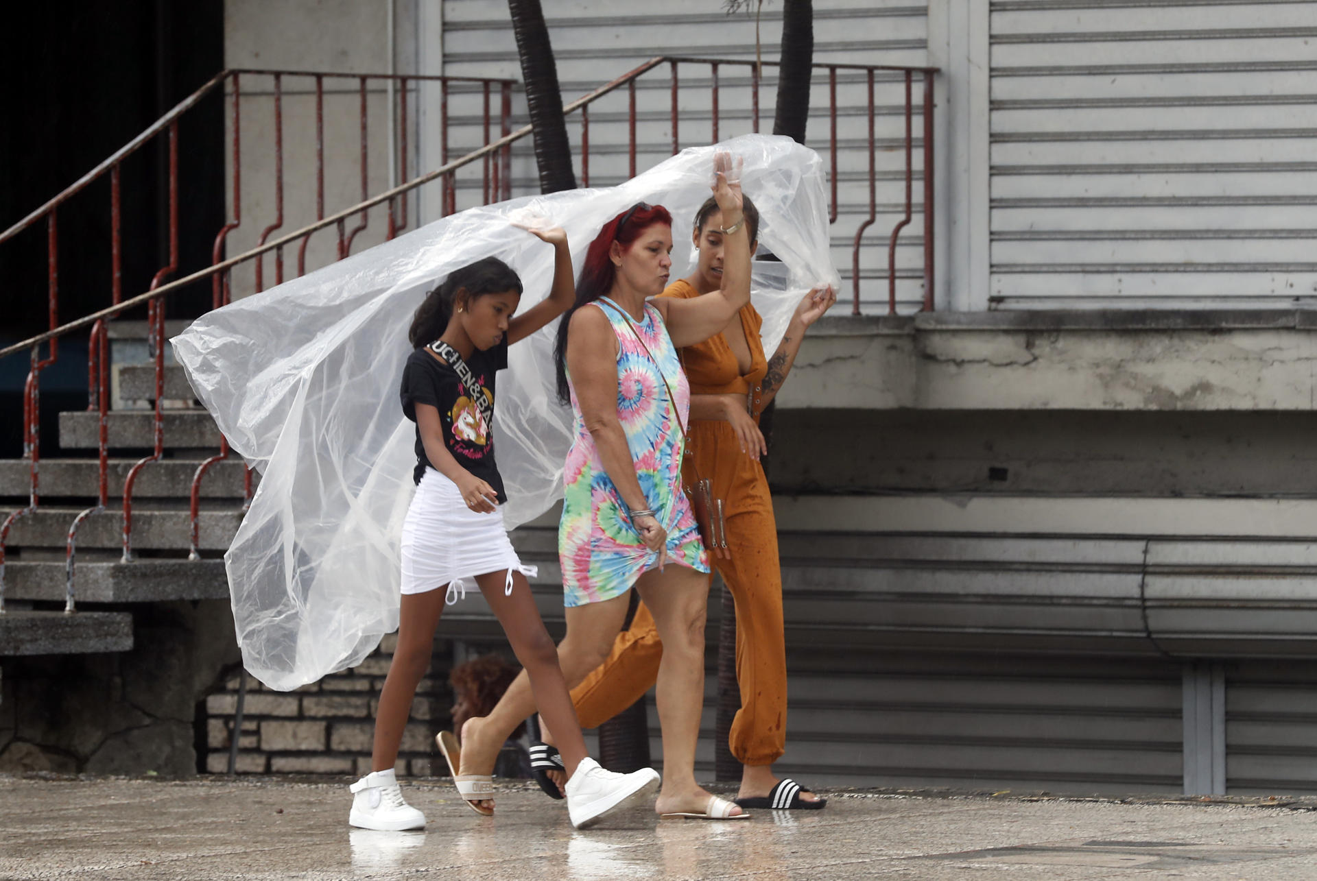 People protect themselves from the rain, in Havana, Cuba, 28 August 2023. EFE-EPA/Ernesto Mastrascusa