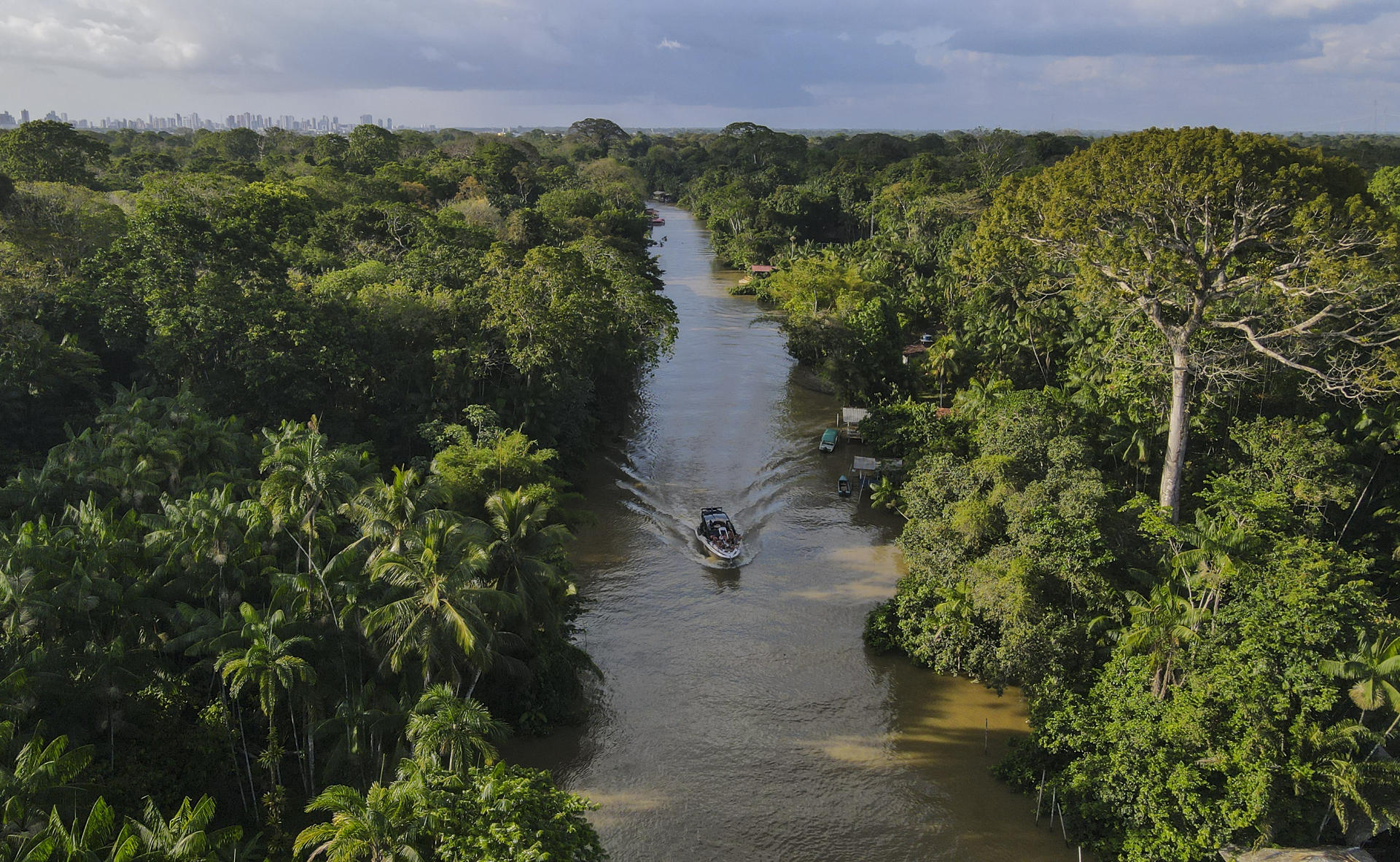 Fotografía aérea de un bote navegando por un río en una zona de la floresta Amazónica, en el estado de Pará, norte de Brasil. EFE/Antonio Lacerda