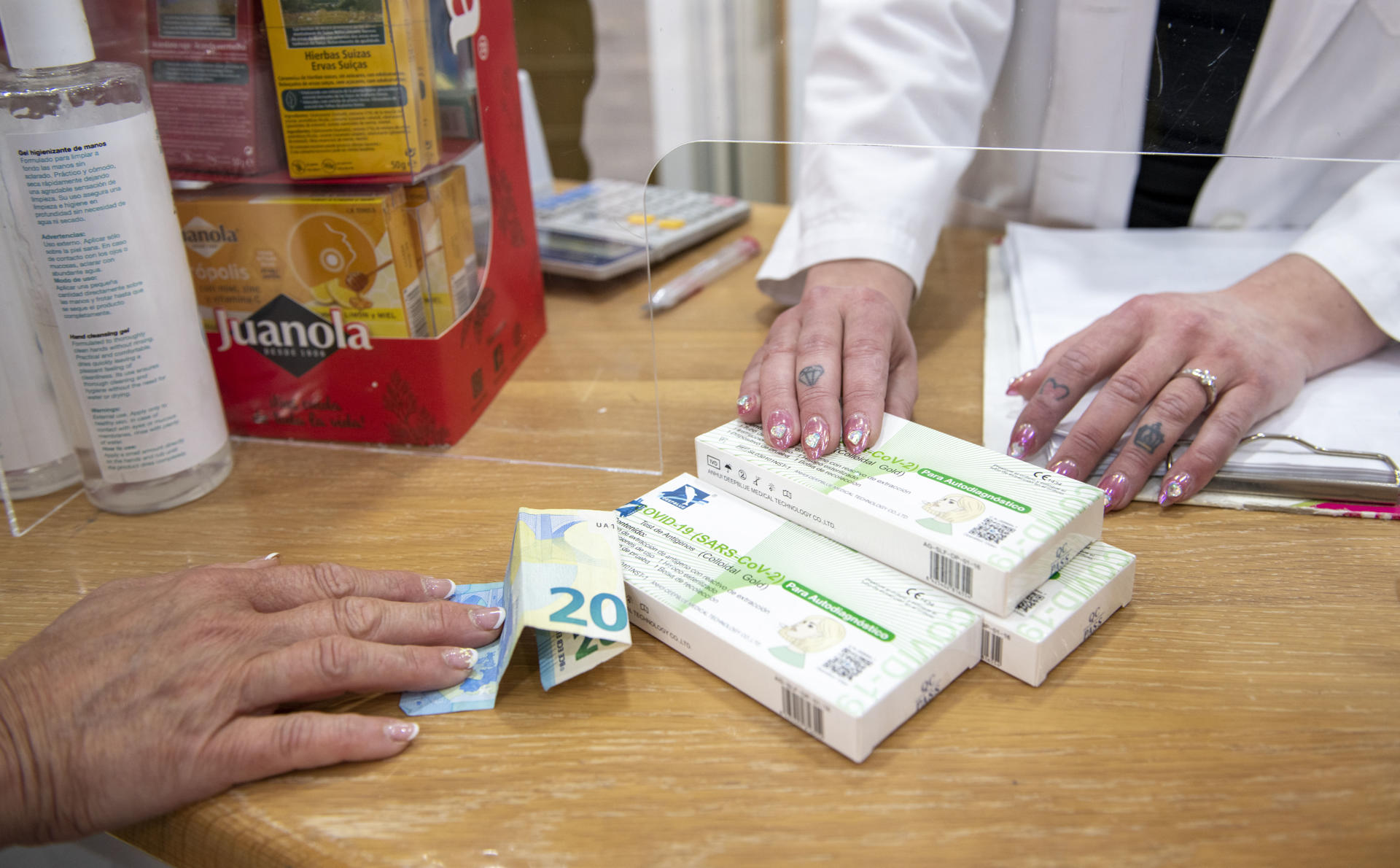 Una farmacéutica vende varios tests de detección de covid en Jaén en una imagen de archivo. EFE/José Manuel Pedrosa