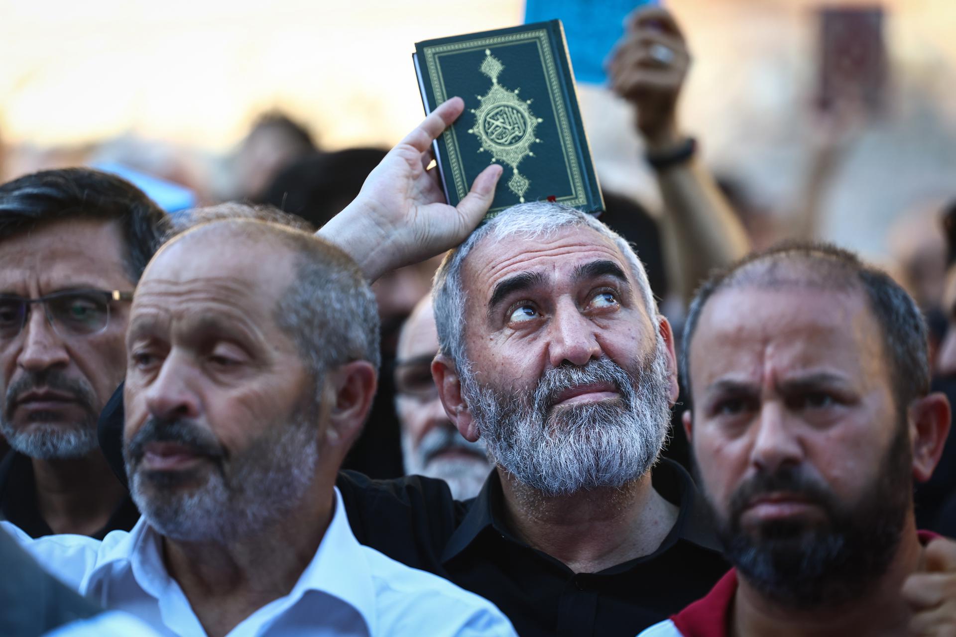 A protester holds a copy of the Koran as they attend a protest against Sweden in front of the Consulate General of Sweden in Istanbul, Turkey, 30 July 2023. EFE/EPA/FILE/SEDAT SUNA