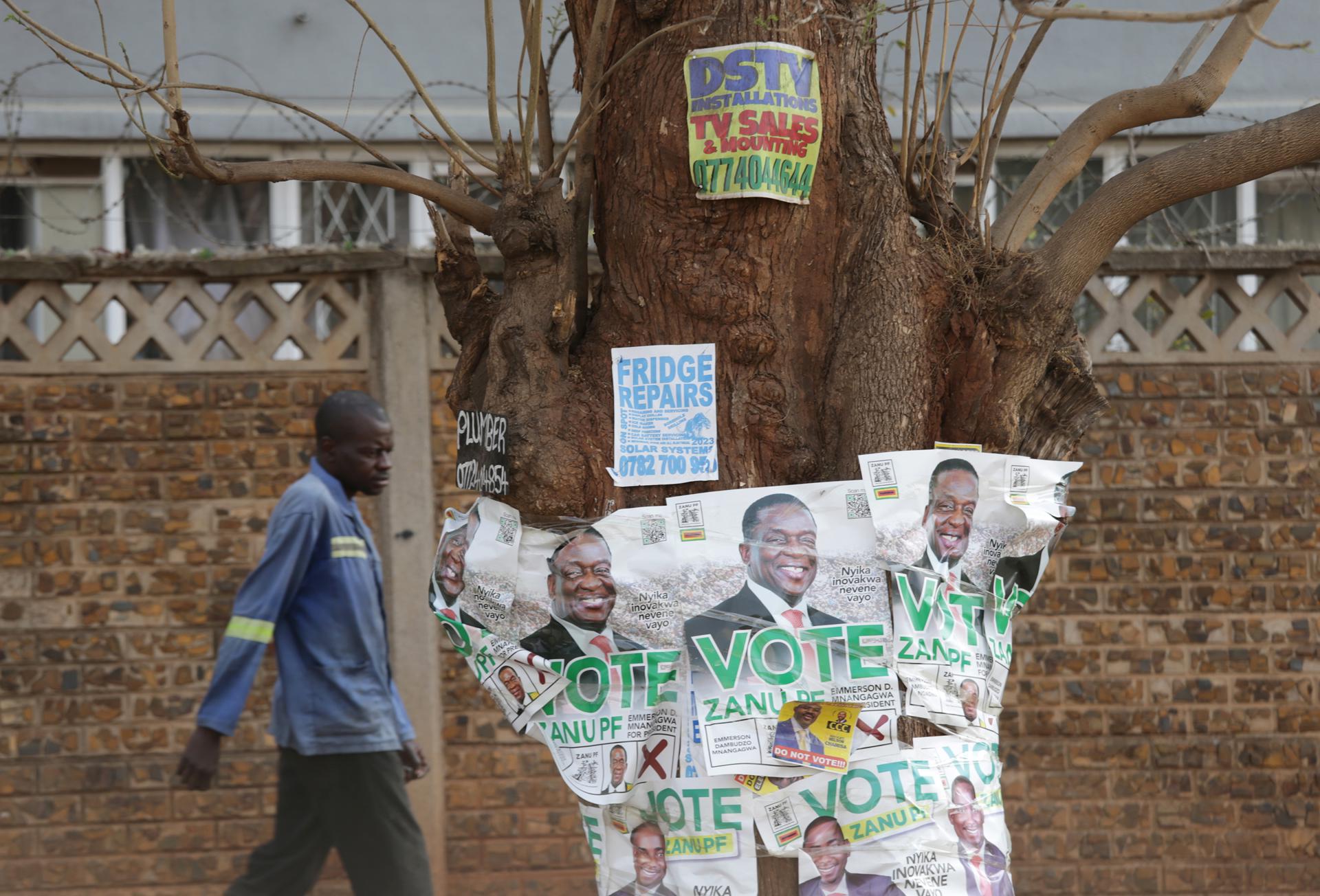 A man walks past election campaign posters of Zimbabwean President Emmerson Mnangagwa in Harare, Zimbabwe, 27 August 2023. EFE-EPA/AARON UFUMELI