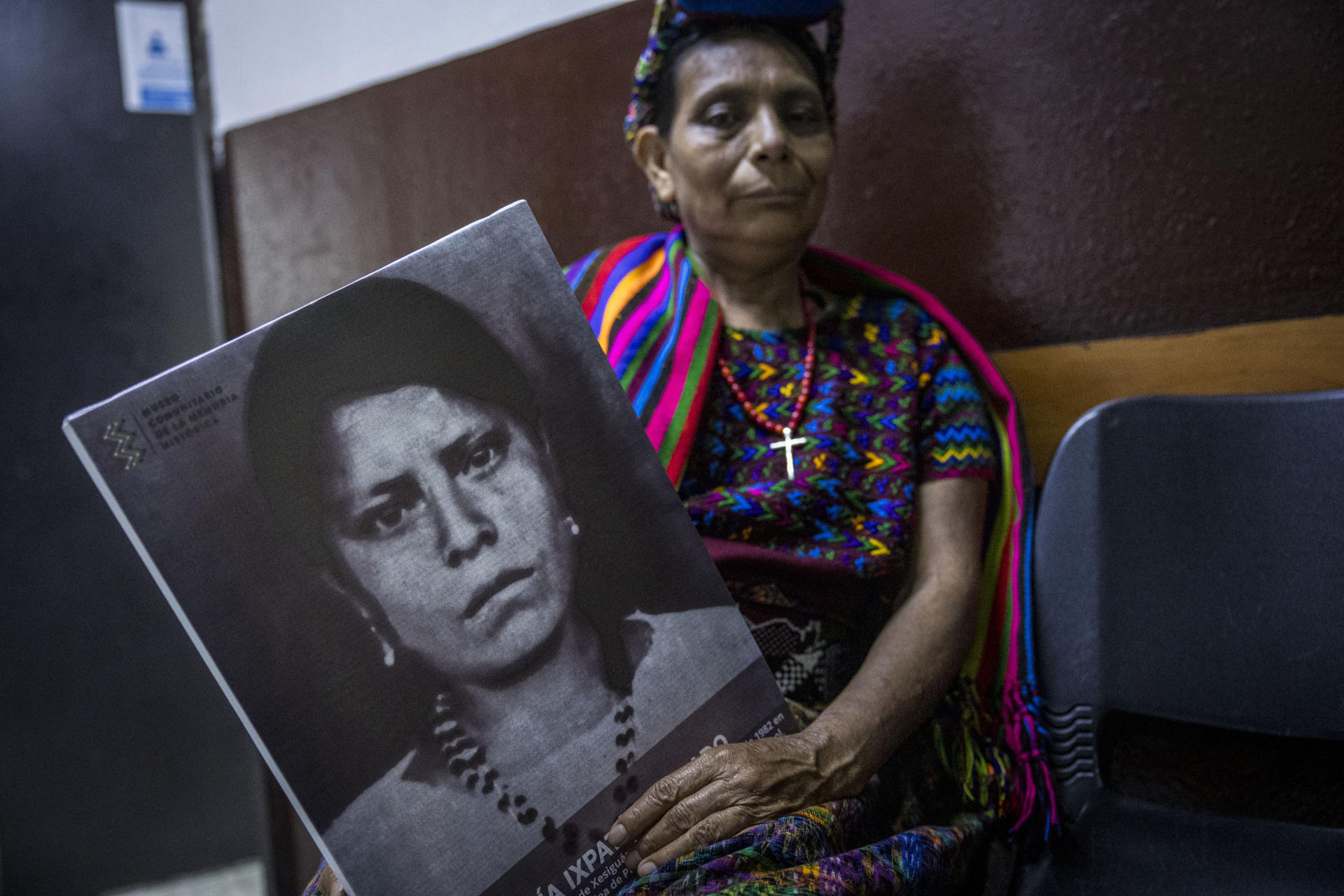 Paulina Ixpatá, sobreviviente de la masacre del Rancho Bejuco posa hoy, con el retrato de su hermana masacrada, en Cuidad de Guatemala (Guatemala). EFE/Esteban Biba