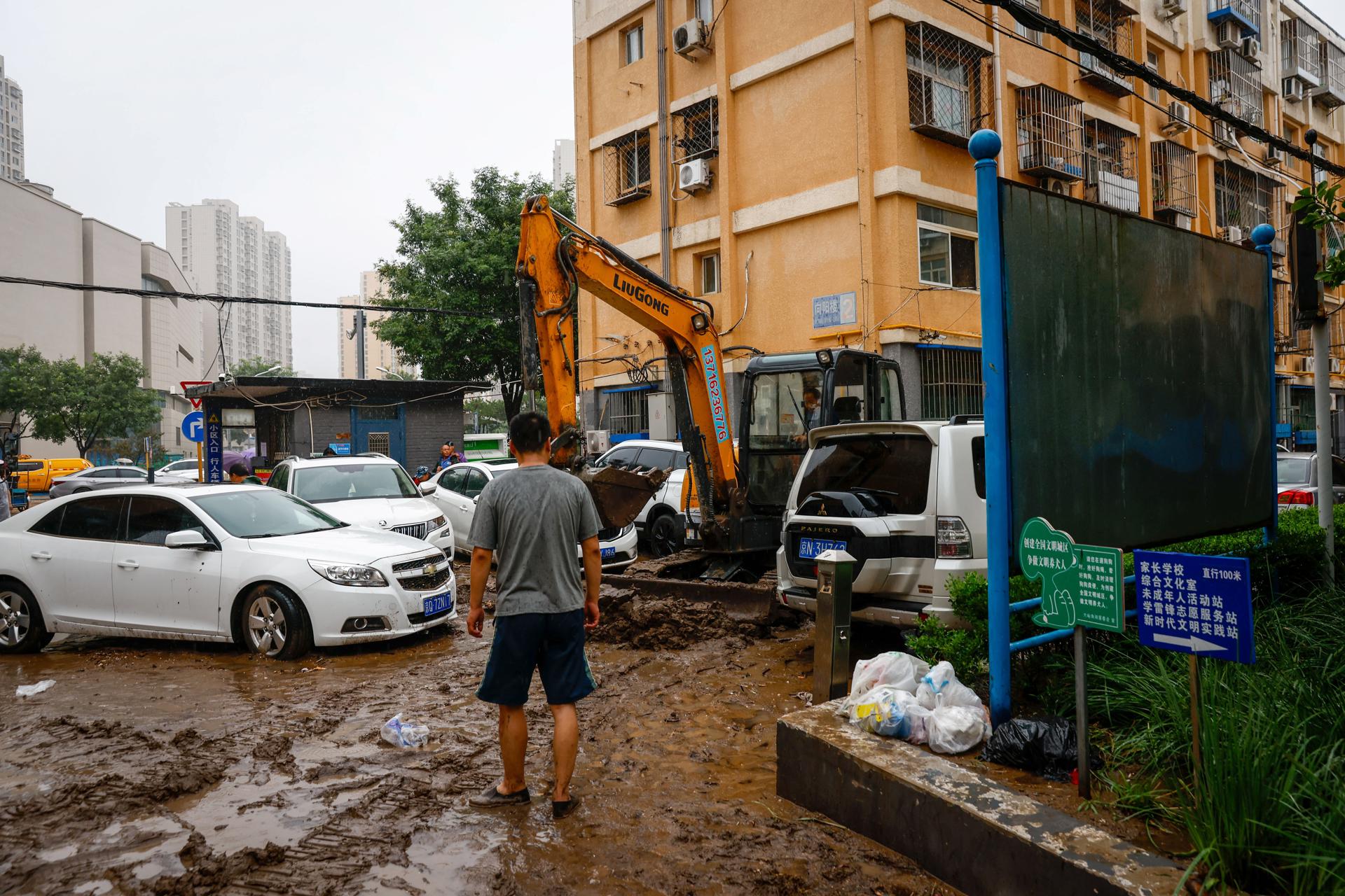 A bulldozer clears mud from a residential compound in Mentougou District, west of Beijing, China, 01 August 2023. EFE-EPA/MARK R. CRISTINO
