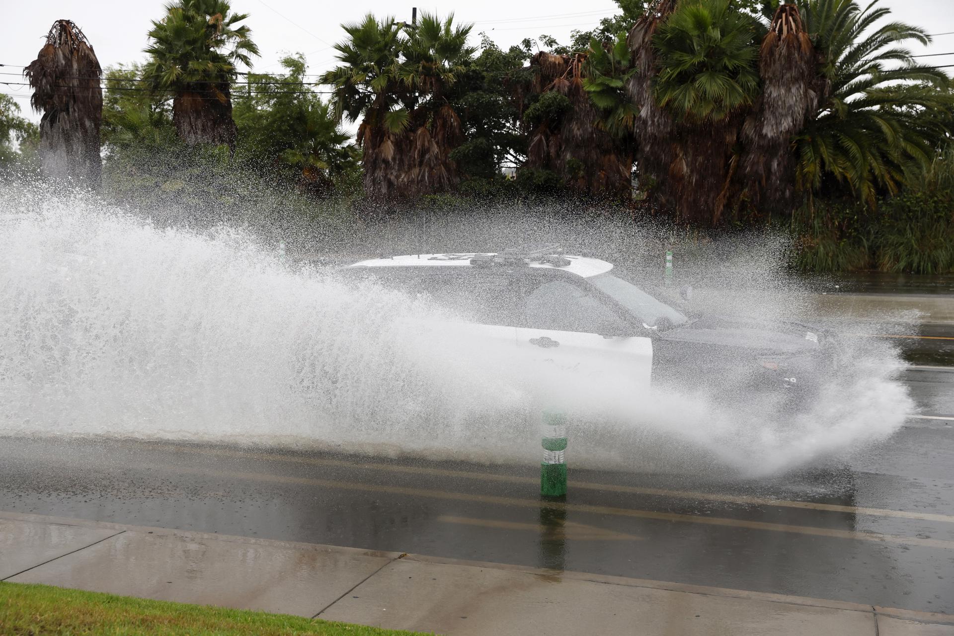 A car drives through standing water on a road in Long Beach, California, USA, 20 August 2023. EFE-EPA/CAROLINE BREHMAN
