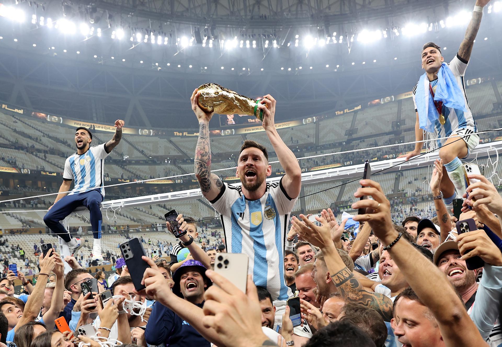 El futbolista argentino Lionel Messi sostiene la Copa Mundial de Fútbol tras ganar el torneo ante Francia en el Estadio de Lusail, en Catar. EFE/Tolga Bozoglu