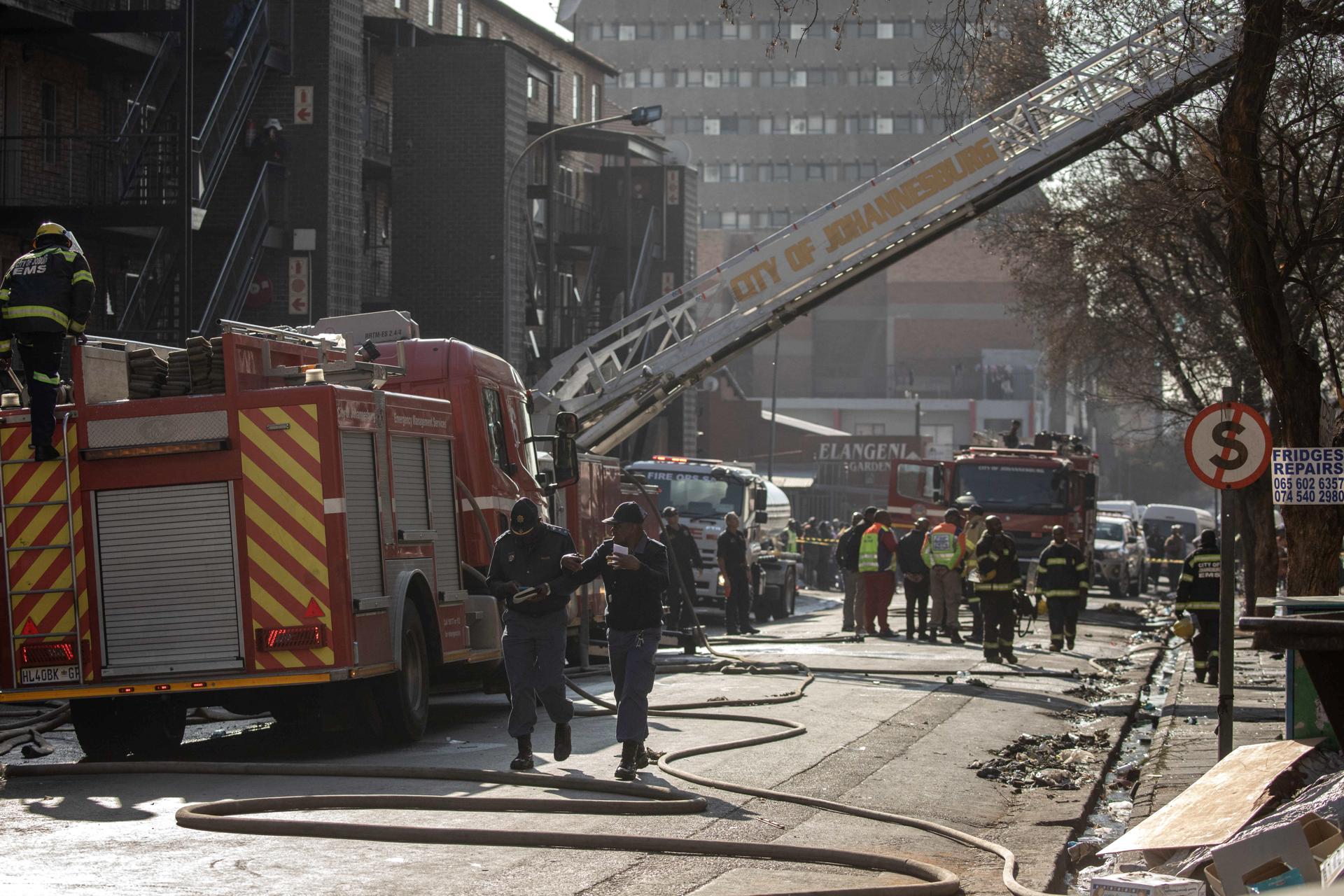 Fire crews, emergency staff and police gather at the site of a fire that broke out at a five-story building in the city center, in Johannesburg, South Africa, 31 August 2023. EFE-EPA/KIM LUDBROOK
