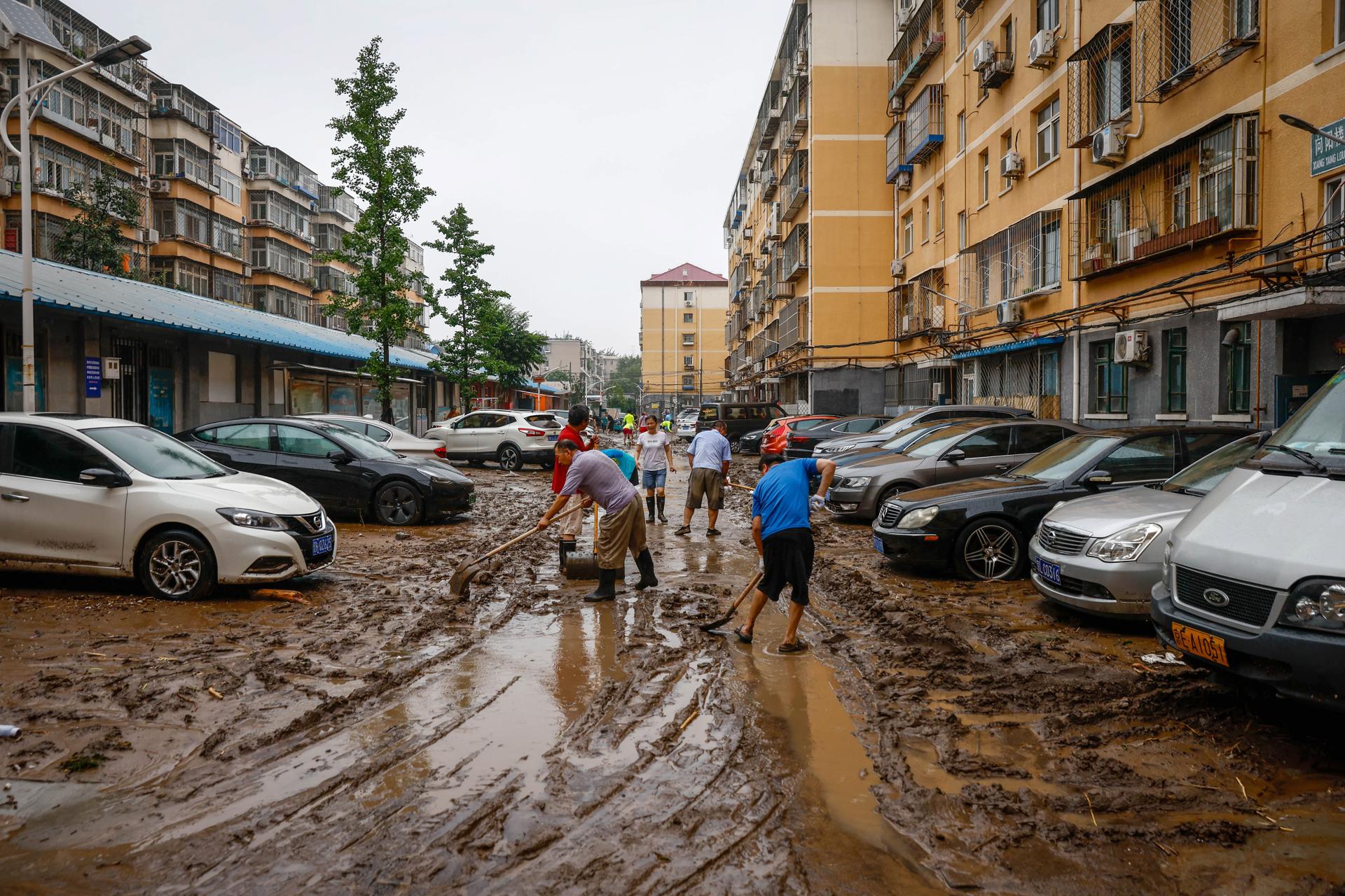 People clear a road from mud inside a residential compound in Mentougou District, west of Beijing, China, 01 August 2023. EFE-EPA/MARK R. CRISTINO
