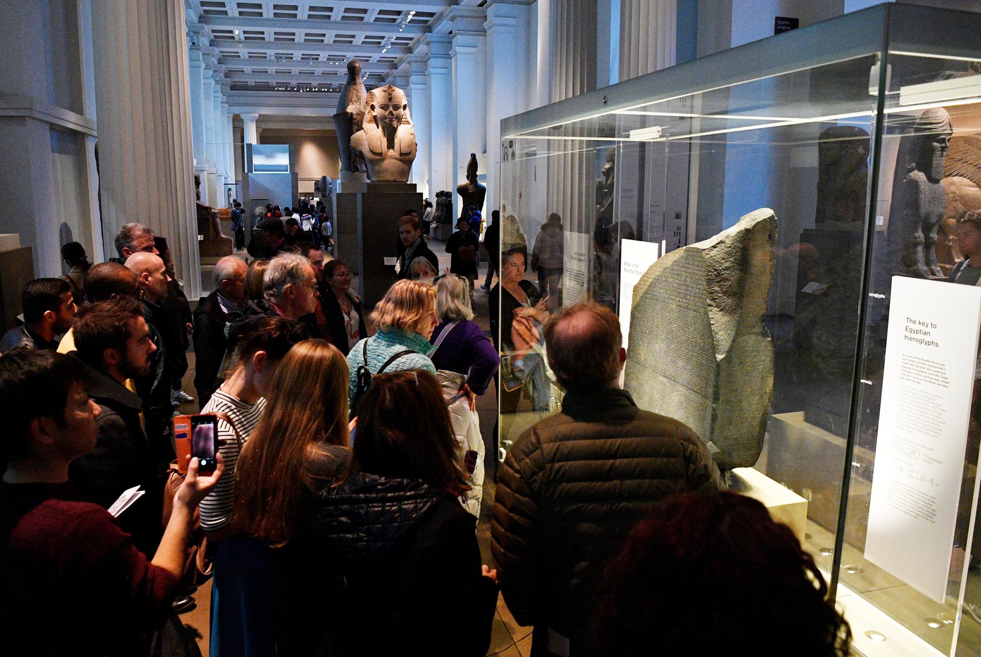 Varios visitantes observan la piedra de Rosetta en el Museo Británico de Londres. EFE/Neil Hall
