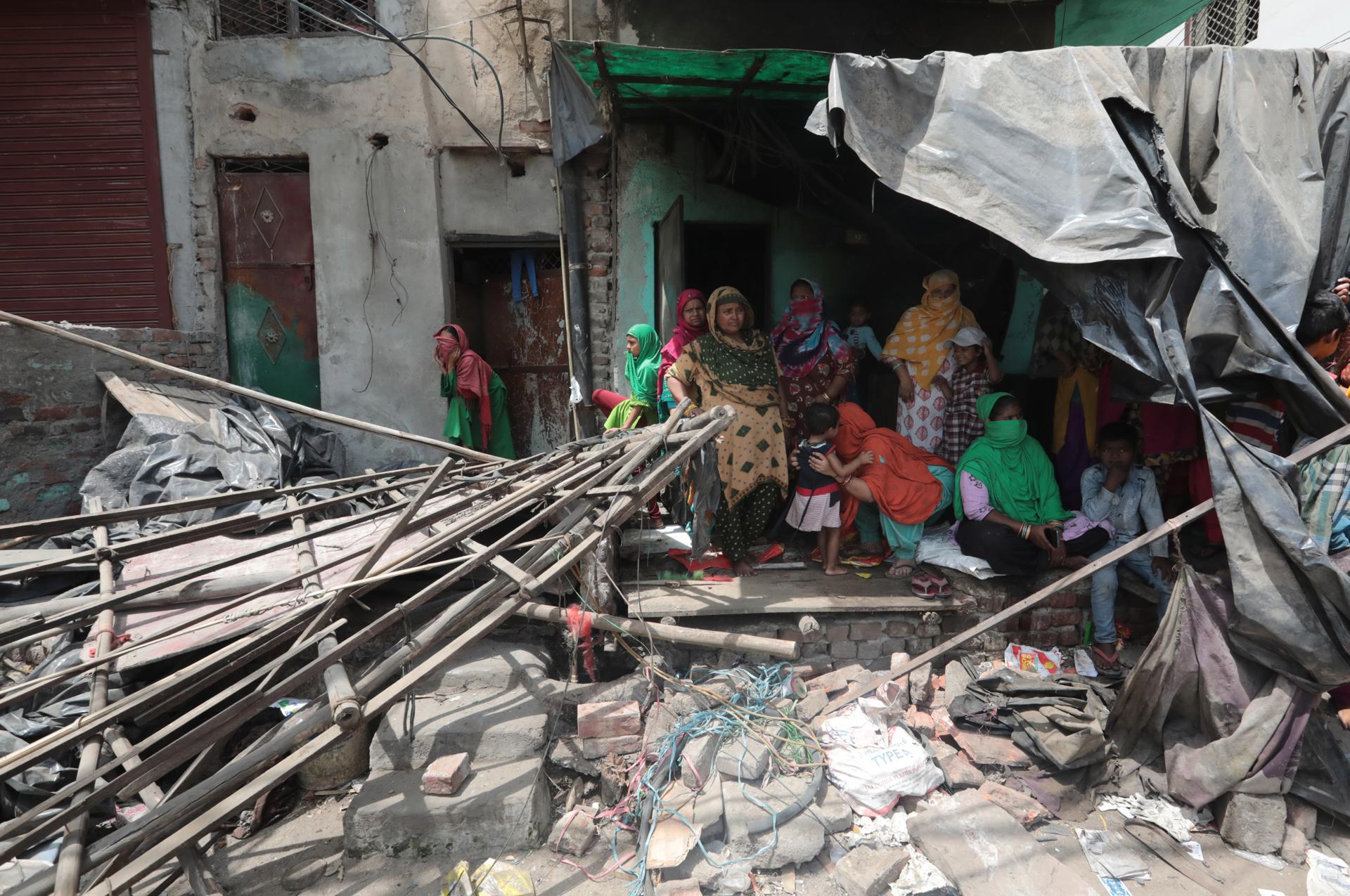 Local residents near dismantled structures during the demolition drive of illegal structures in Delhi's violence-hit Jahangirpuri in New Delhi, India 20 April 2022. EFE-EPA FILE/RAJAT GUPTA
