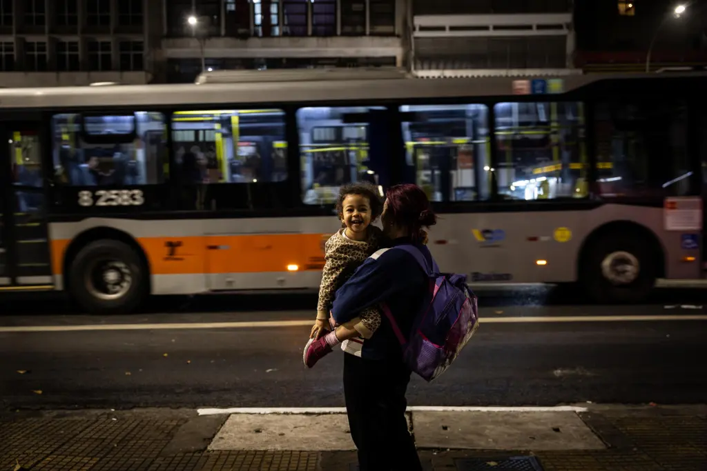 Una mujer y una niña esperan en una de las paradas de autobús que forman parte del proyecto Abrigo Amigo, el 29 de agosto de 2023, en el centro de São Paulo (Brasil). EFE/Isaac Fontana
