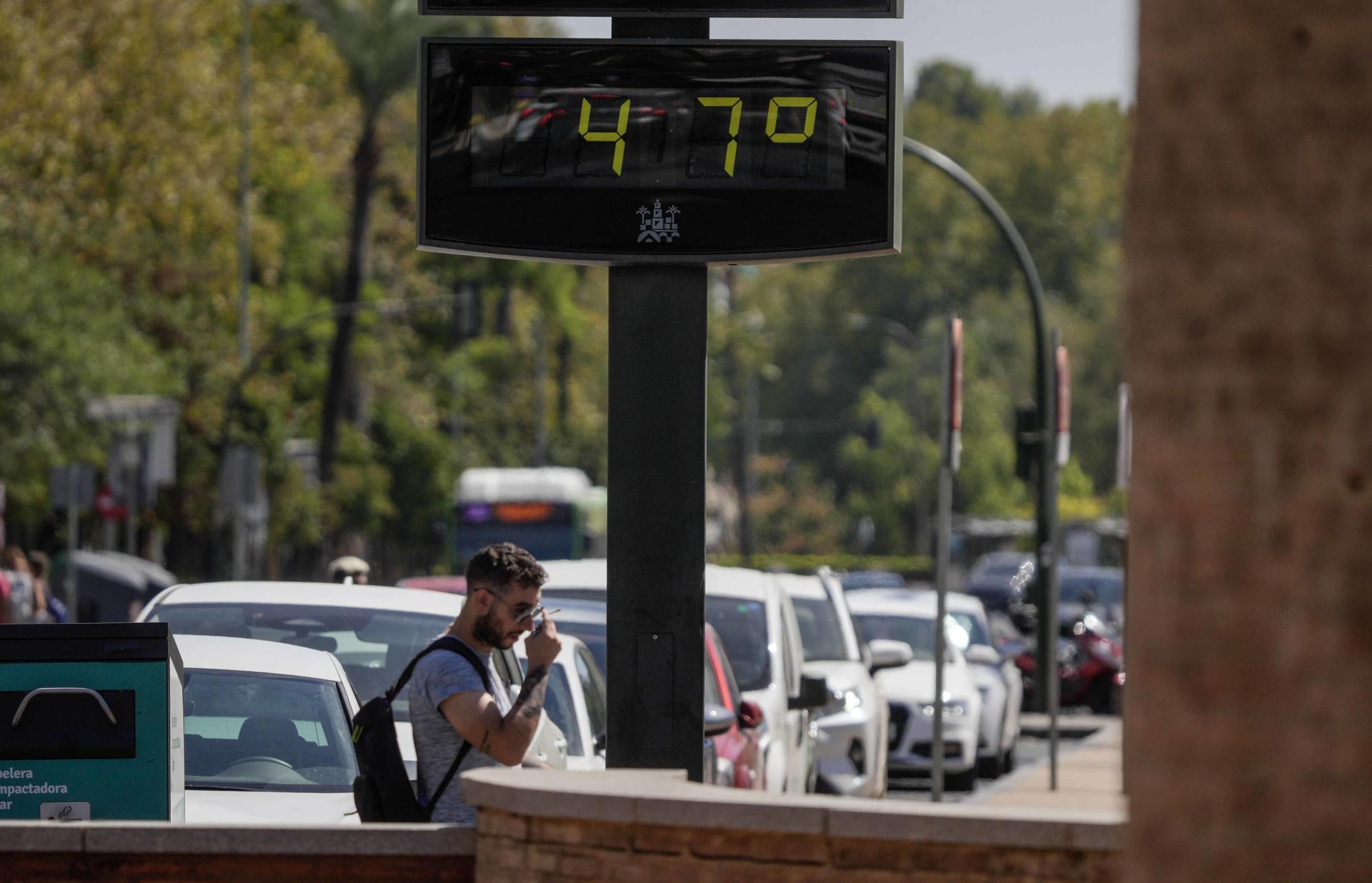 A man passes by a street thermometer that marks 47 Celsius degrees during the fourth heatwave of the summer 2023 in Cordoba, southern Spain 23 August 2023. EFE/ Rafa Alcaide
