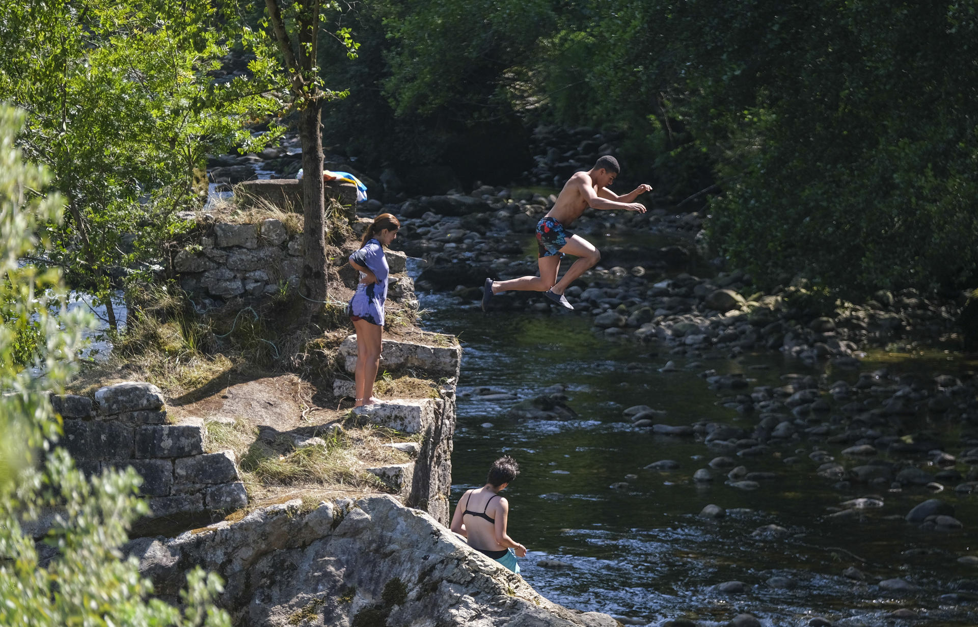 Bañistas refrescándose en el agua esta tarde en el río TrubiaEFE/Paco Paredes