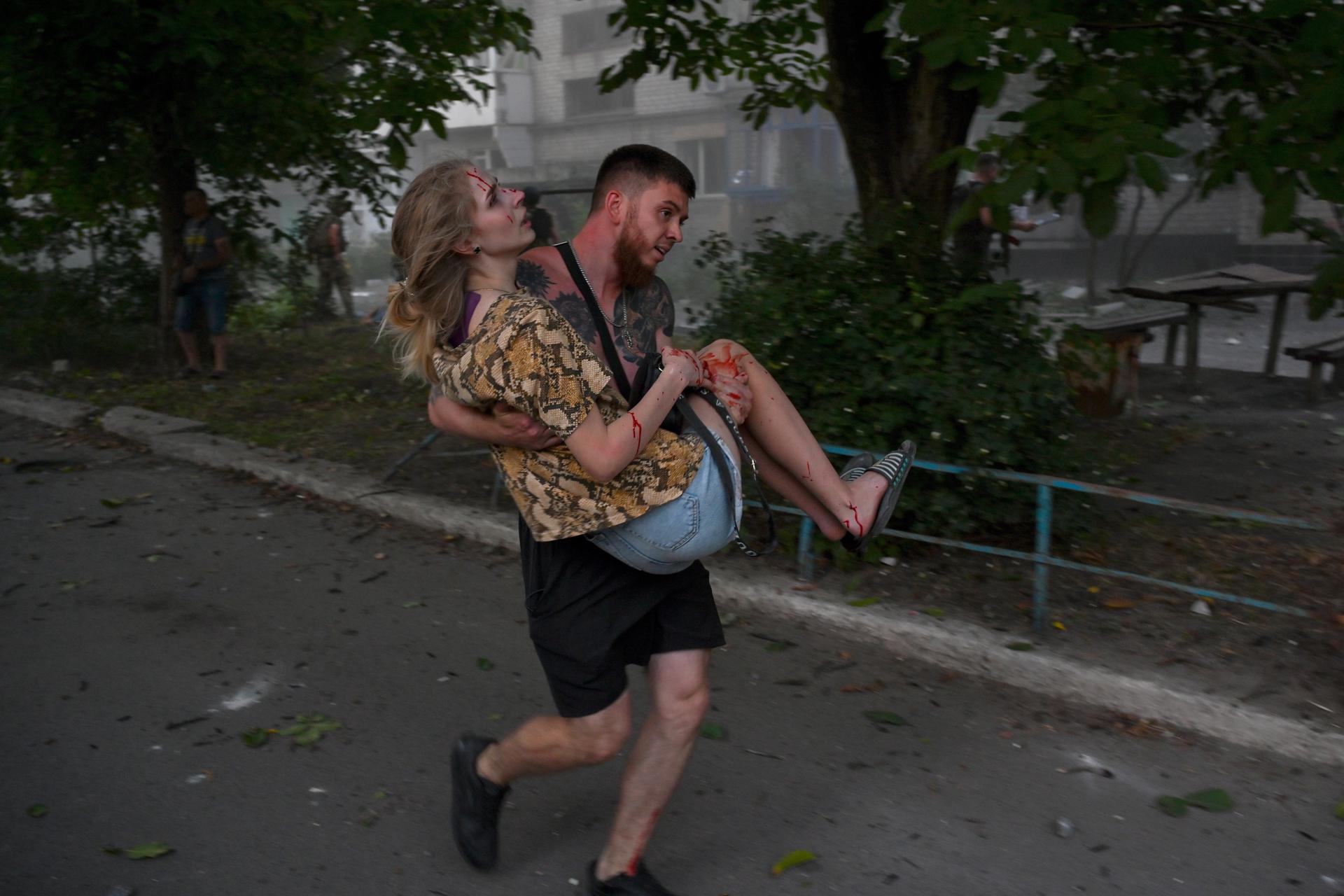 A man carries an injured Ukrainian woman after an explosion of a second rocket in the city of Pokrovsk, Donetsk area, Ukraine, 07 August 2023. EFE-EPA/STANISLAV KRUPAR