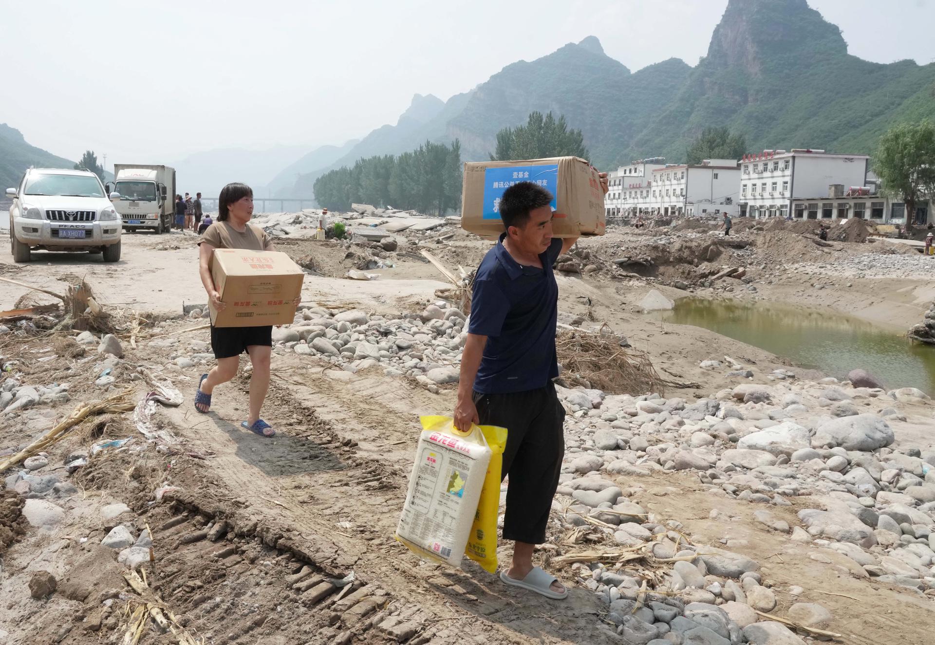 Villagers carrying disaster relief rice walk back home in Shangzhuang Village of Sanpo Town, Laishui County, north China's Hebei Province, 09 August 2023 (issued 10 August 2023). EFE-EPA/XINHUA/Yang Shiyao CHINA OUT/MANDATORY CREDIT EDITORIAL USE ONLY

