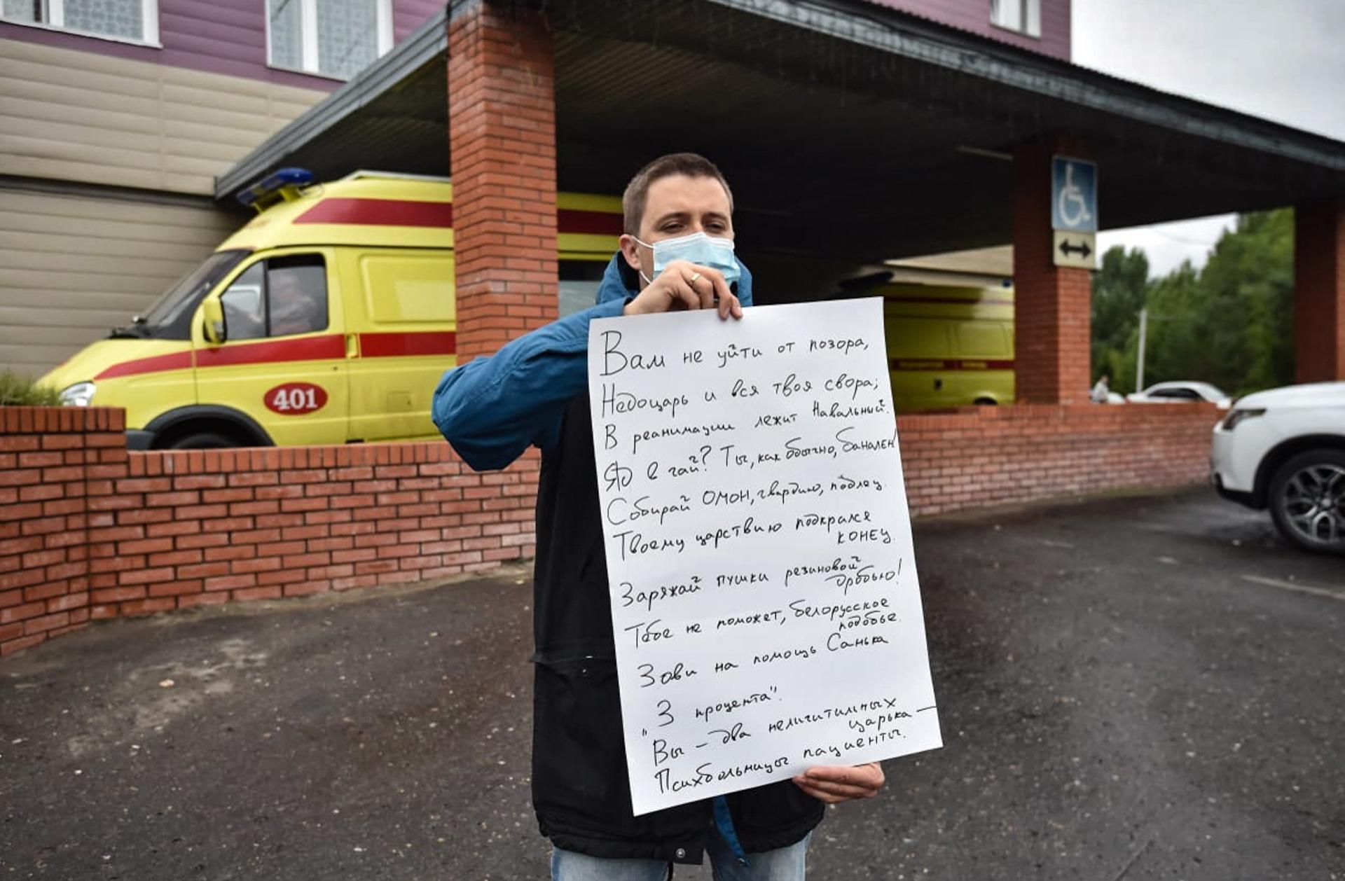An opposition protester demonstrates his poem devoted to the case of alleged poisoning of a known opposition figure Alexei Navalny in front of a hospital of emergency medical care -1 in Omsk, Russia, 20 August 2020. EFE-EPA/FILE/MAXIM KARLAYEV
