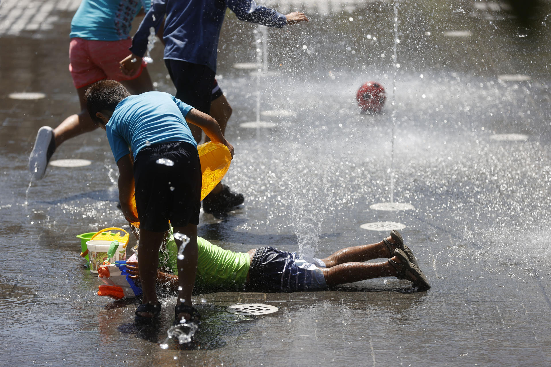Varias personas se refrescan en las fuente instaladas en la zona de Madrid Río, este miércoles. EFE/Juan Carlos Hidalgo