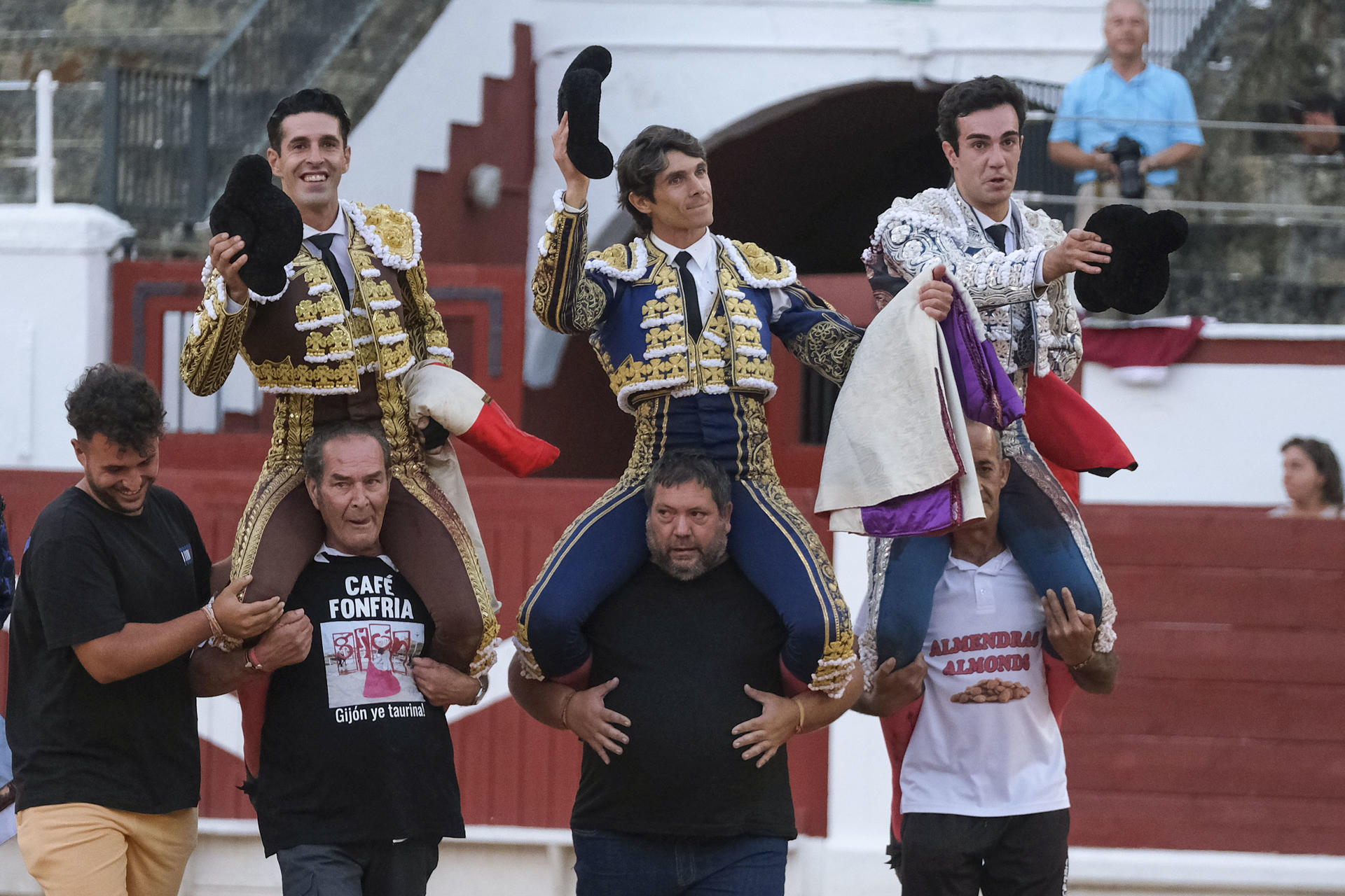 Los diestros Tomás Rufo (d), Sebastián Castella (c) y Alejandro Talavante salen a hombros durante la corrida de la Feria Taurina de Begoña, este viernes en la Plaza de Toros de El Bibio , en Gijón. EFE/Paco Paredes