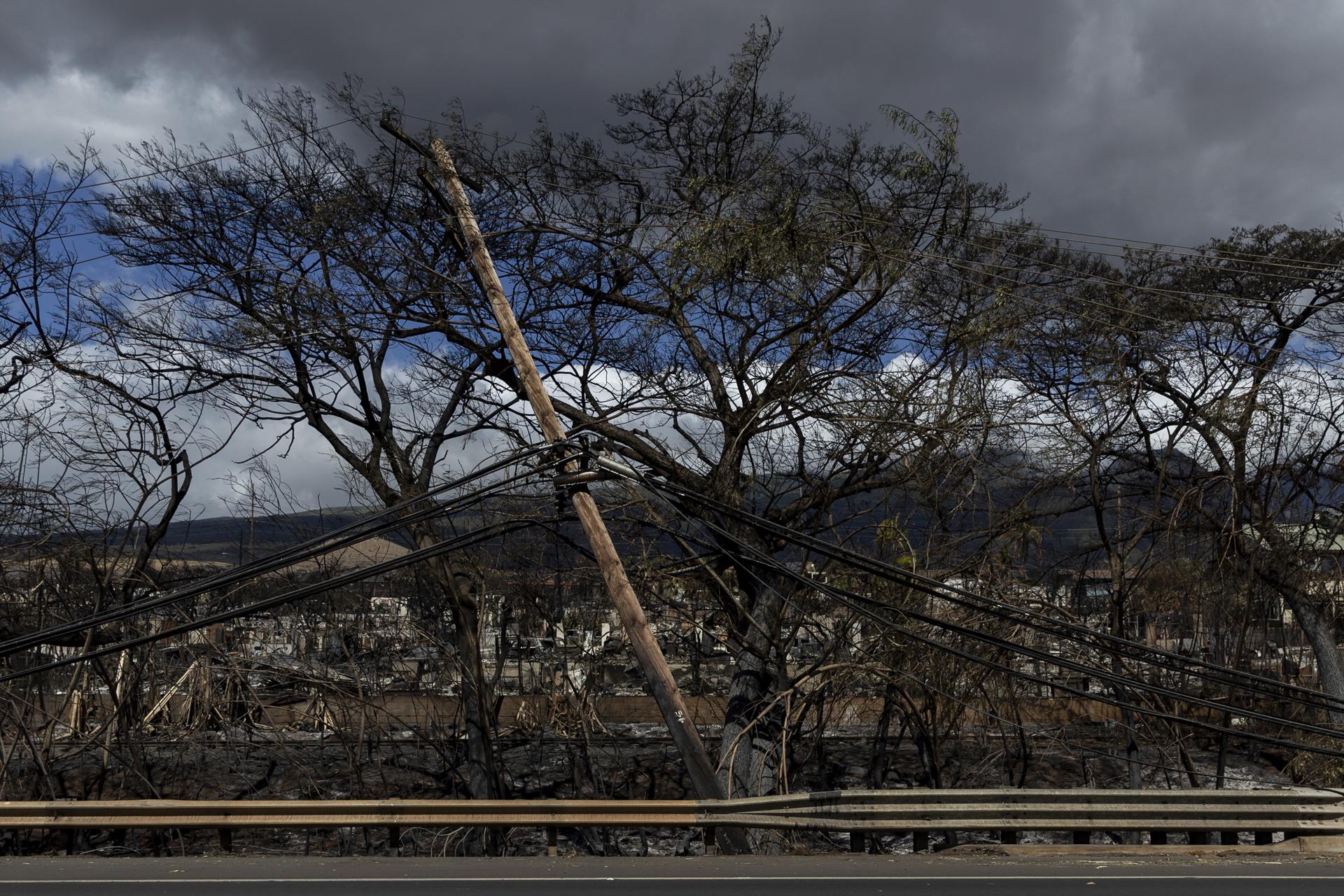 A fallen power line near burned out cars and houses are all that remains after a wildfire swept through a neighborhood in Lahaina, Hawaii, US, 15 August 2023. EFE-EPA/ETIENNE LAURENT
