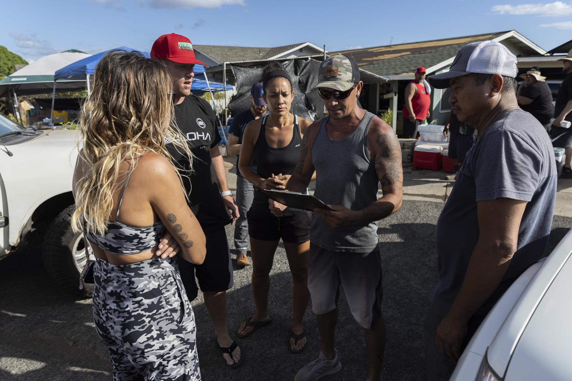 The organizer of a makeshift community food, water and necessities distribution location checks on a list the products he needs as people from Oahu and Maui distribute goods in a neighborhood of Lahaina, Hawaii, USA, 13 August 2023. EFE-EPA/ETIENNE LAURENT/FILE