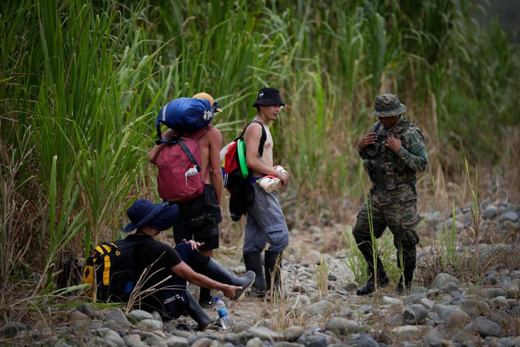 Un agente del Servicio Nacional de Fronteras de Panamá (SENAFRONT) orienta a un grupo de migrantes, en la comunidad de Bajo Chiquito, Darién (Panamá), en una fotografía de archivo. EFE/Bienvenido Velasco
