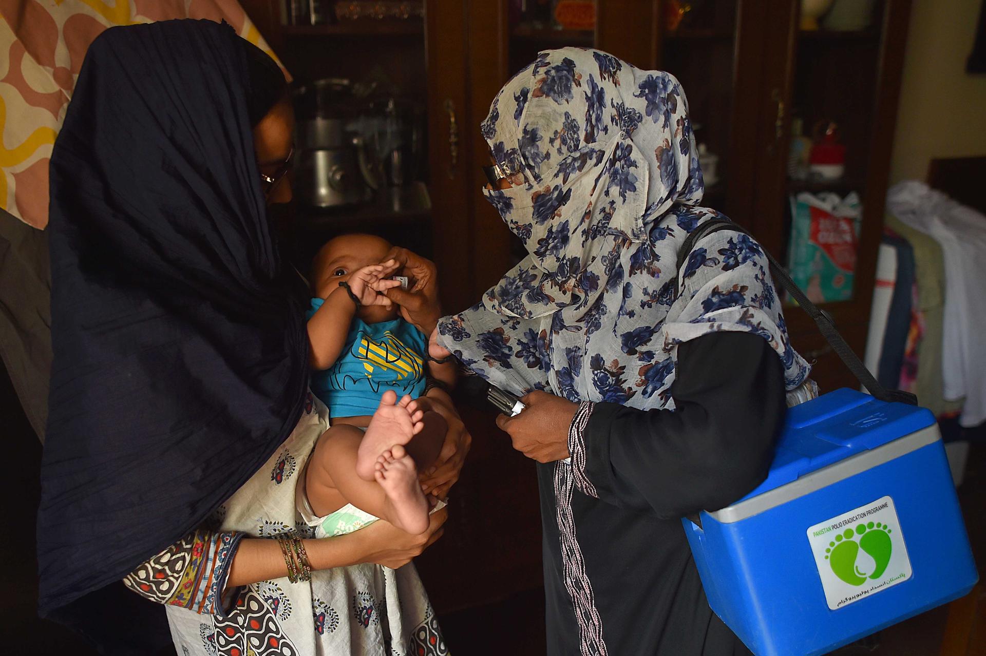 A child gets the polio vaccine administered from a health worker in Karachi, Pakistan, 20 June 2023. EFE-EPA FILE/SHAHZAIB AKBER