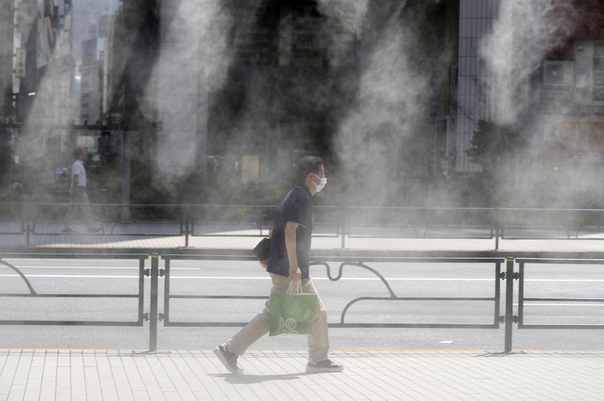 A passerby walks past a mist spray on a hot day in Tokyo, Japan, 11 July 2023. EFE-EPA FILE/FRANCK ROBICHON
