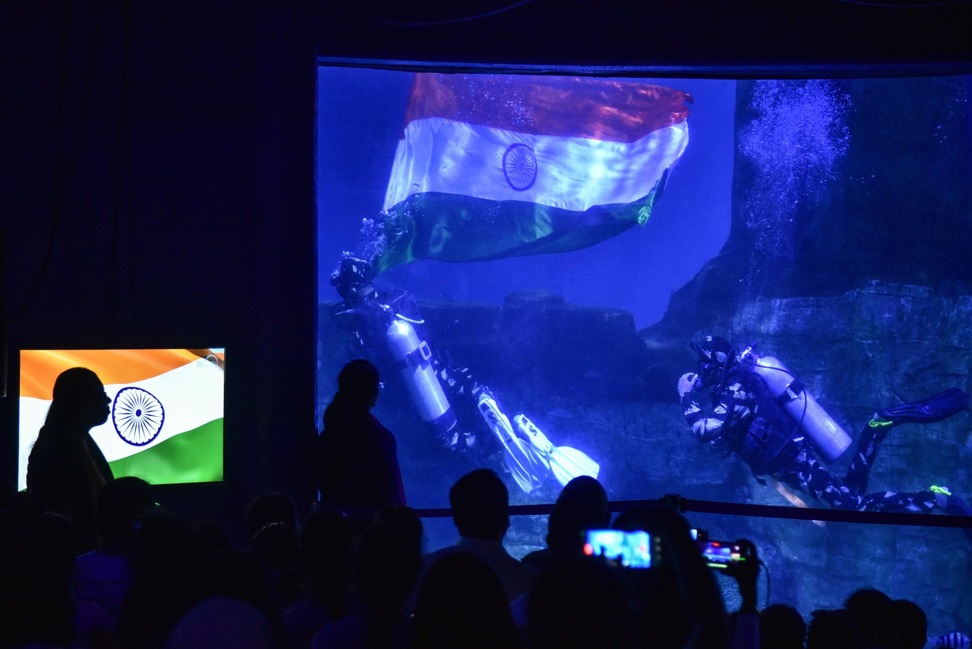 Visitors watch as scuba divers dressed as Indian army soldiers display the Indian national flag during an underwater show on the eve of the 77th Independence Day, at a marine theme park, in Chennai, India, 14 August 2023. EFE-EPA/IDREES MOHAMMED
