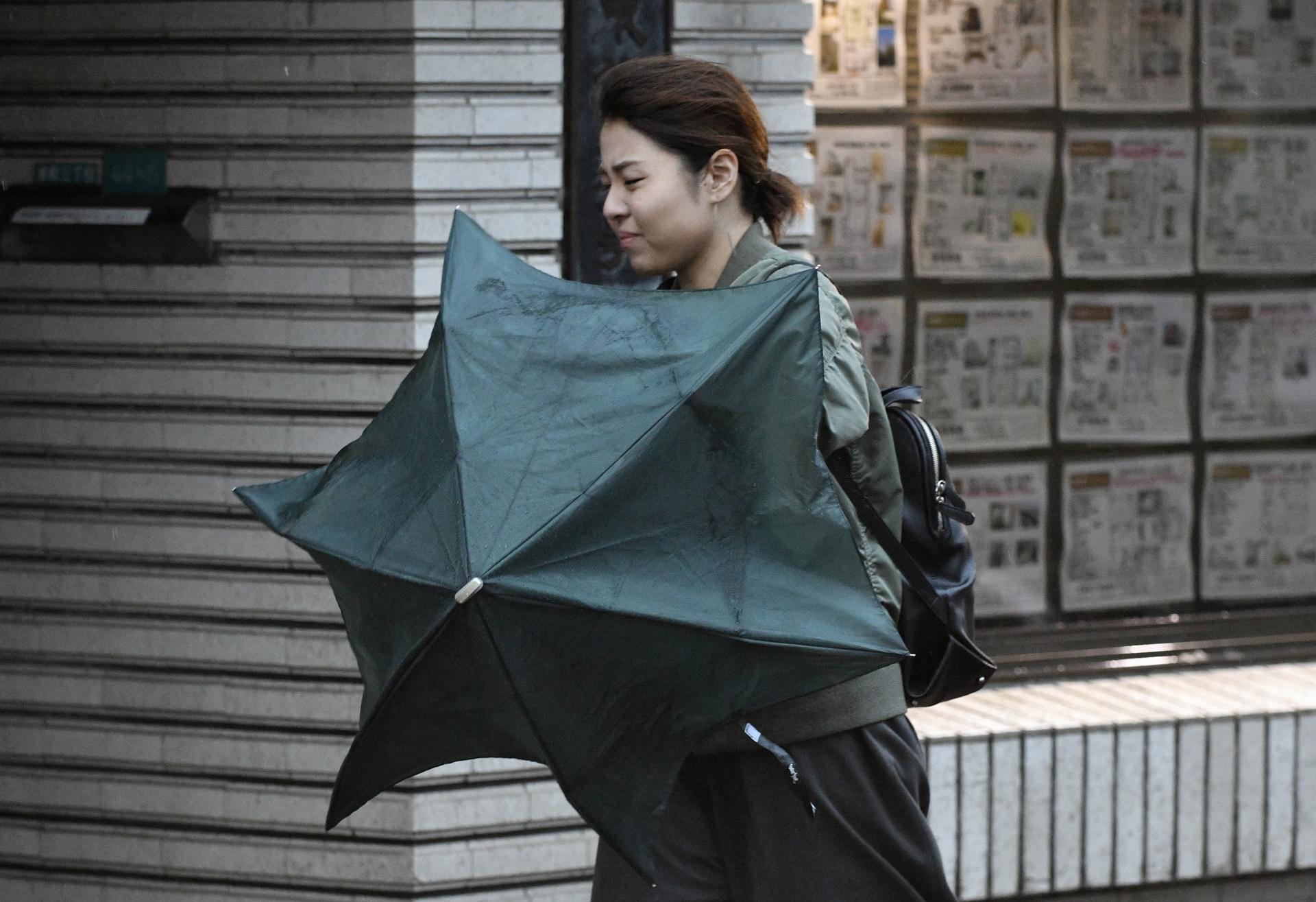 A woman uses an umbrella to shield herself from strong wind in Tokyo, Japan, 23 October 2017. EFE-EPA FILE/FRANCK ROBICHON