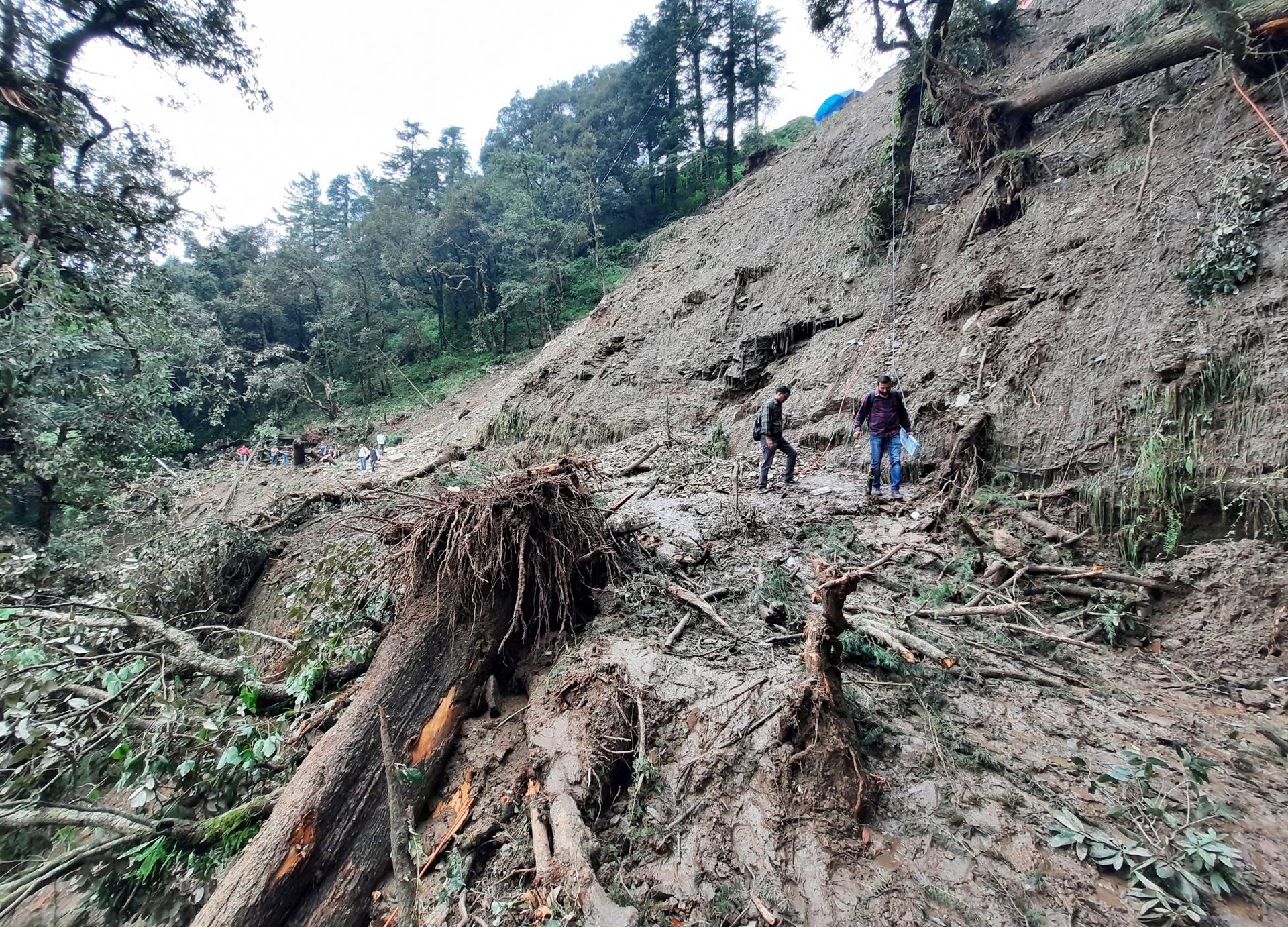 People try to cross a damaged road after a landslide in Shimla, Himachal Pradesh, India, 16 August 2023. EFE/EPA/STR
