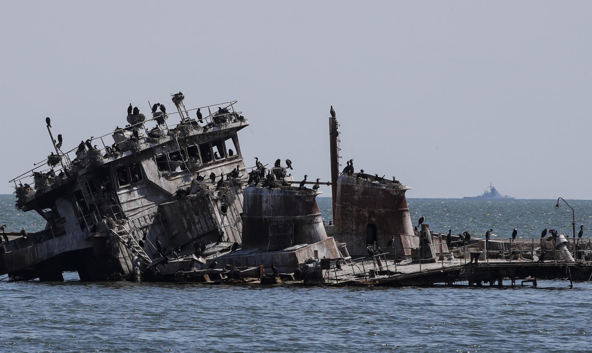 A file picture taken during a visit to Mariupol organized by the Russian military shows Russian warship guards in the Azov Sea behind a sunken Ukrainian ship on the cargo sea port of Mariupol, Ukraine, 29 April 2022. EFE-EPA/SERGEI ILNITSKY