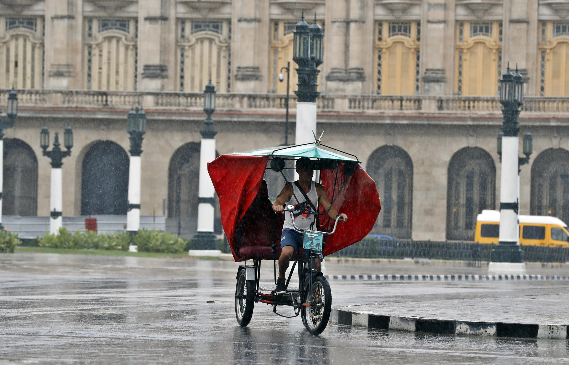 A man drives his rickshaw in the rain, near the Capitol in Havana, Cuba, 28 August 2023. EFE-EPA/Ernesto Mastrascusa

