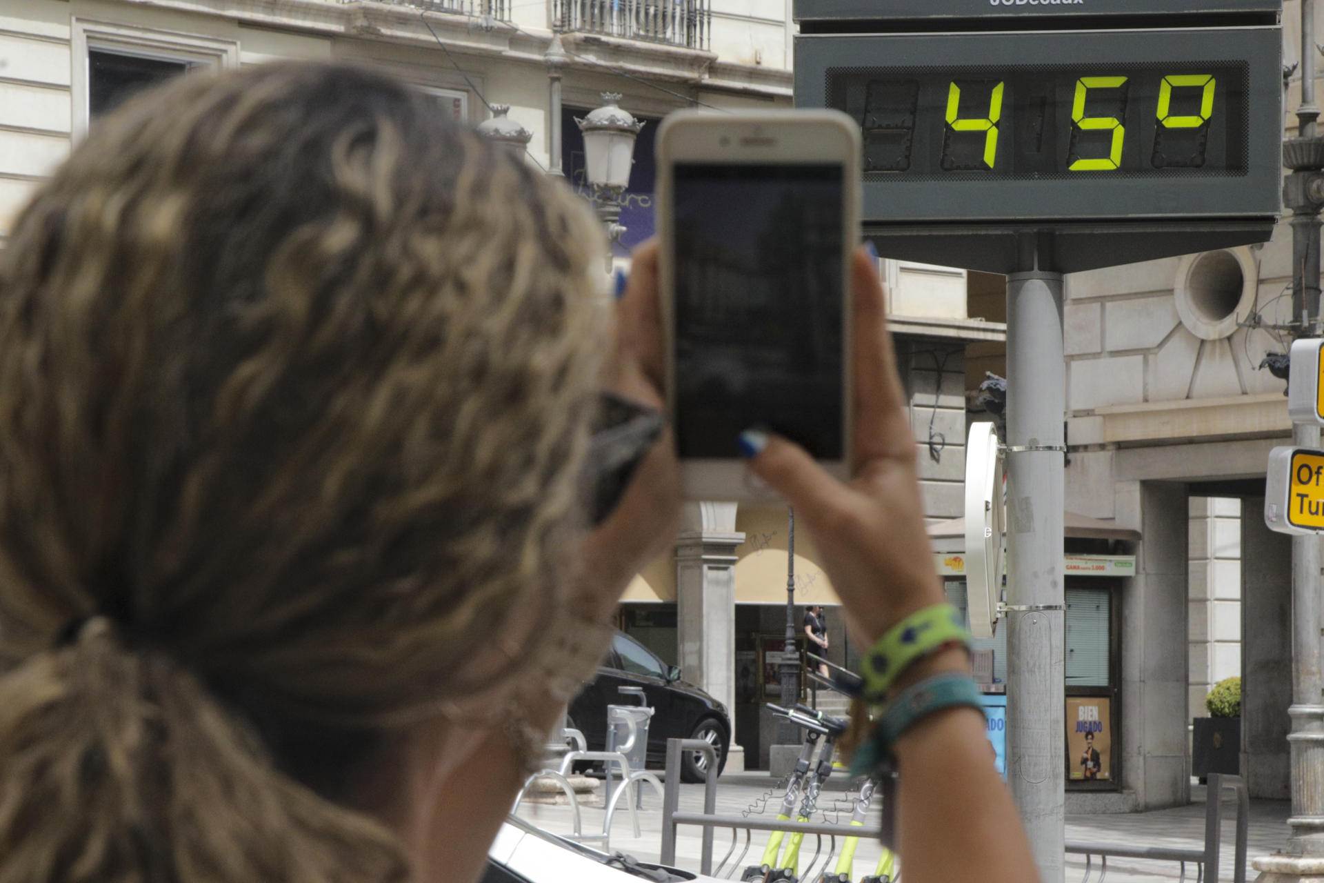 Una mujer fotografía la temperatura de un termómetro en Granada.