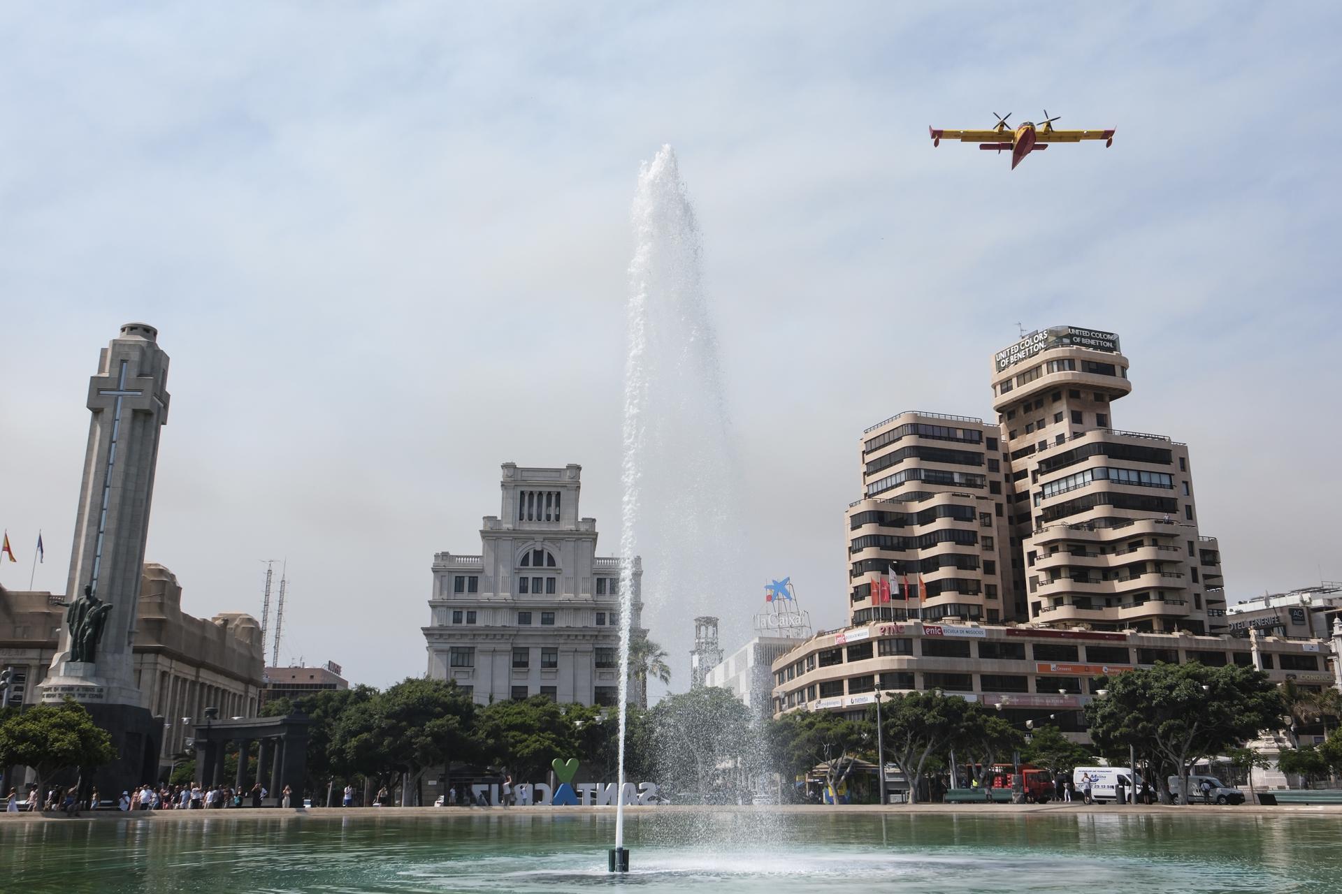 Un hidroavión destinado a las labores de extinción del incendio forestal que afecta a la isla de Tenerife sobrevuela la capital de la isla durante una operación de recarga de agua. EFE/Alberto Valdés