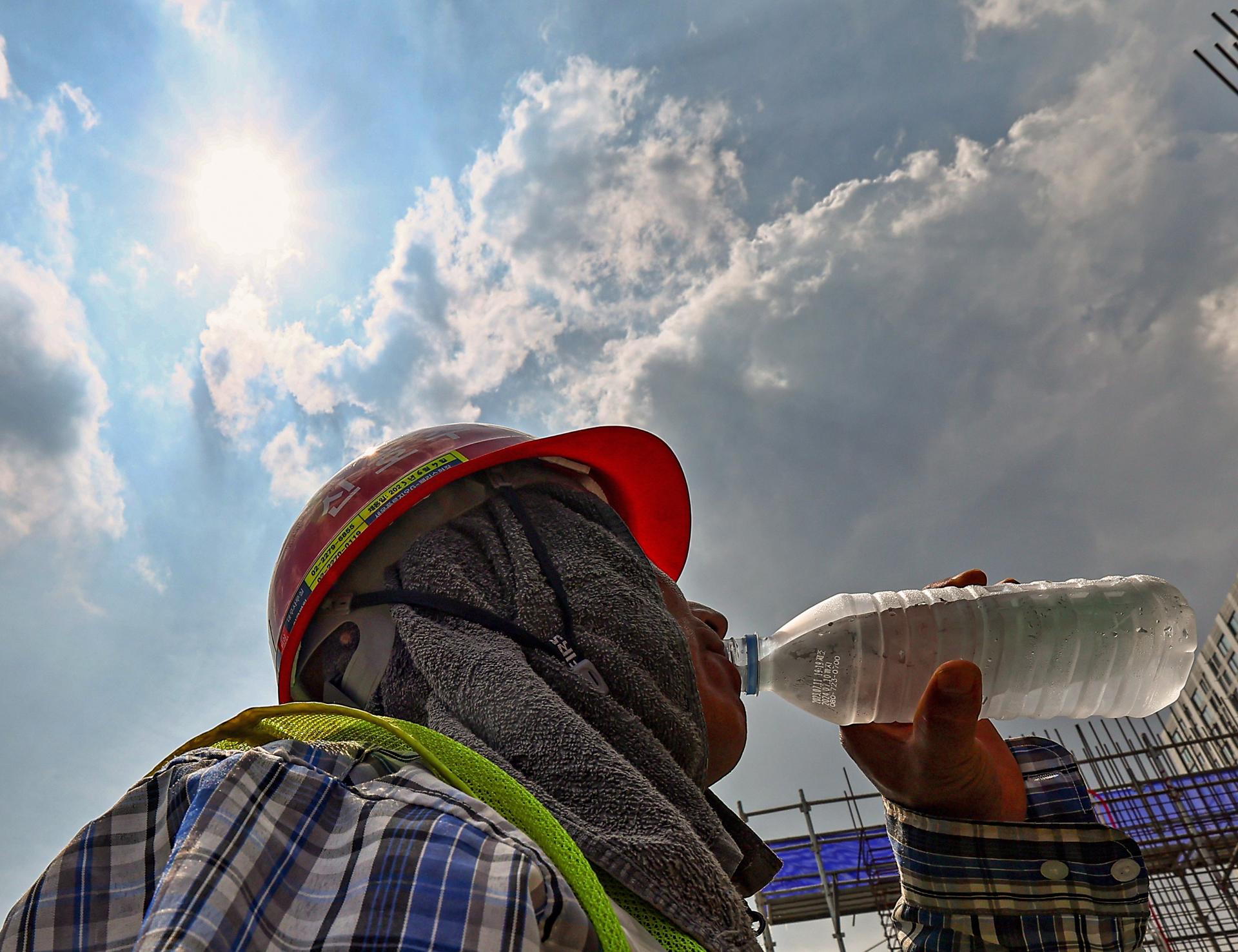 (FILE) A worker gulps down water while standing under a scorching sun at a construction site in Seoul, South Korea, 01 August 2023.  EFE/EPA/YONHAP SOUTH KOREA OUT