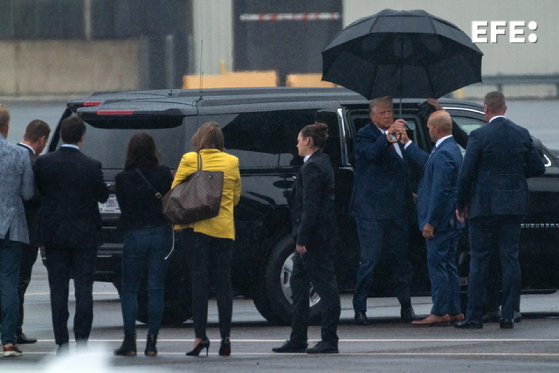 Arlington, Virginia (United States), 03/08/2023.- An aide hands former US President Donald J. Trump an umbrella as he arrives (3-R) at Ronald Reagan Washington National Airport after Judge Tanya Sue Chutkan arraigned him in Washington, in Arlington, Virginia, USA, 03 August 2023. A federal grand jury has indicted Trump over his efforts to overturn the 2020 presidential election. EFE/EPA/ERIC LEE
