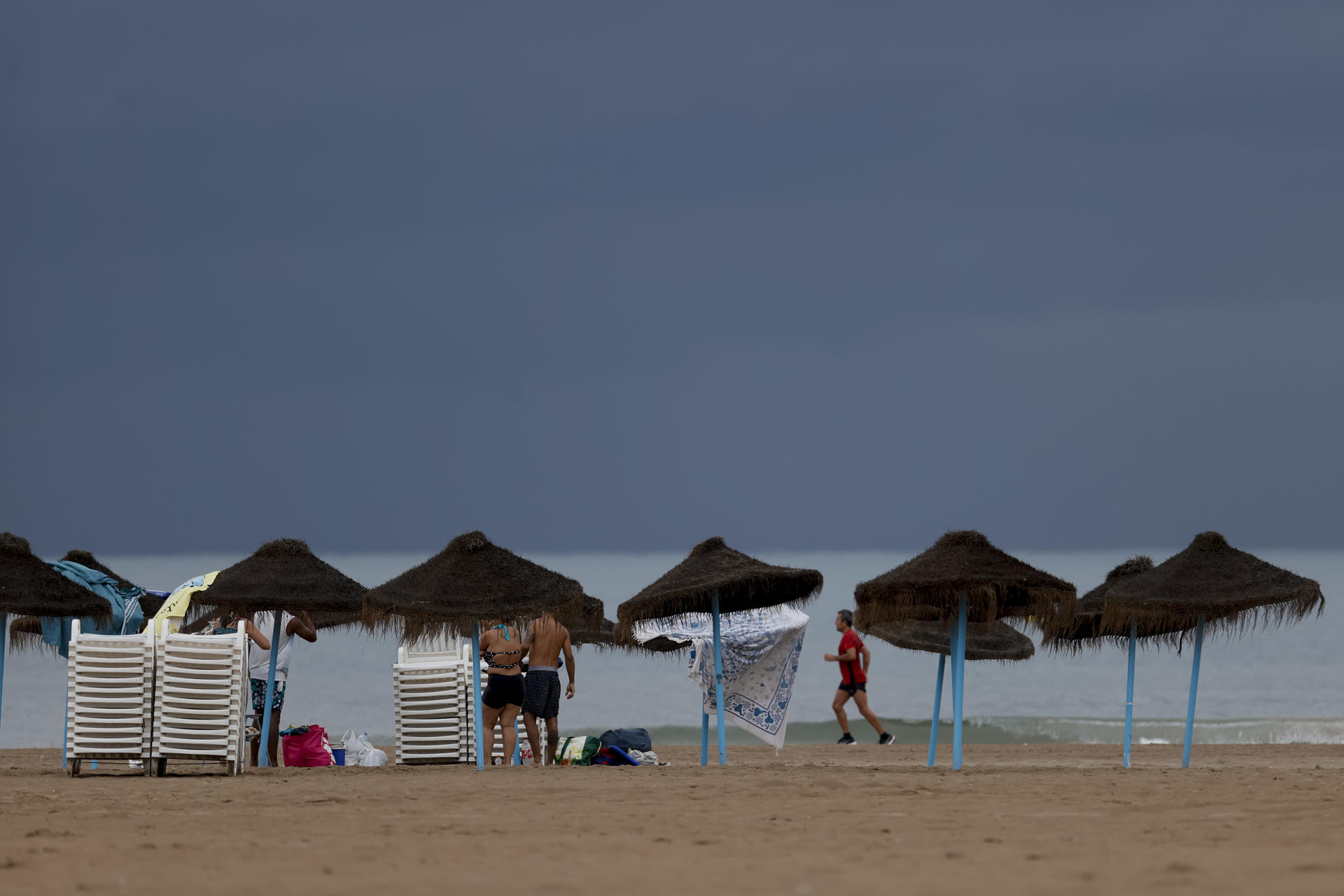La playa de la Malvarrosa hoy tras la tormenta caída esta noche y con una bajada de 10 grados de temperatura. EFE/ Juan Carlos Cárdenas