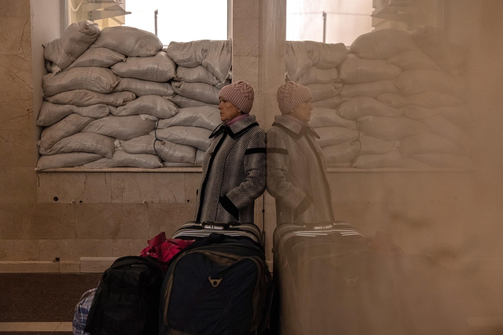 Nina, who spent the whole time in Kherson during the Russian occupation, waits for her family members next to luggage before boarding an evacuation train heading to Kyiv, at the railway station in Kherson, southern Ukraine, 23 November 2022. (Issued on 21 February 2023). EFE-EPA FILE/ROMAN PILIPEY
