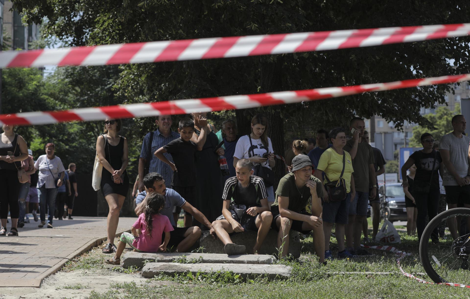 Locals gather near a cordon at the site of a damaged residential building after shelling in the city of Kryvyi Rih, central Ukraine, 31 July 2023, amid the Russian invasion. EFE-EPA/ARSEN DZODZAIEV