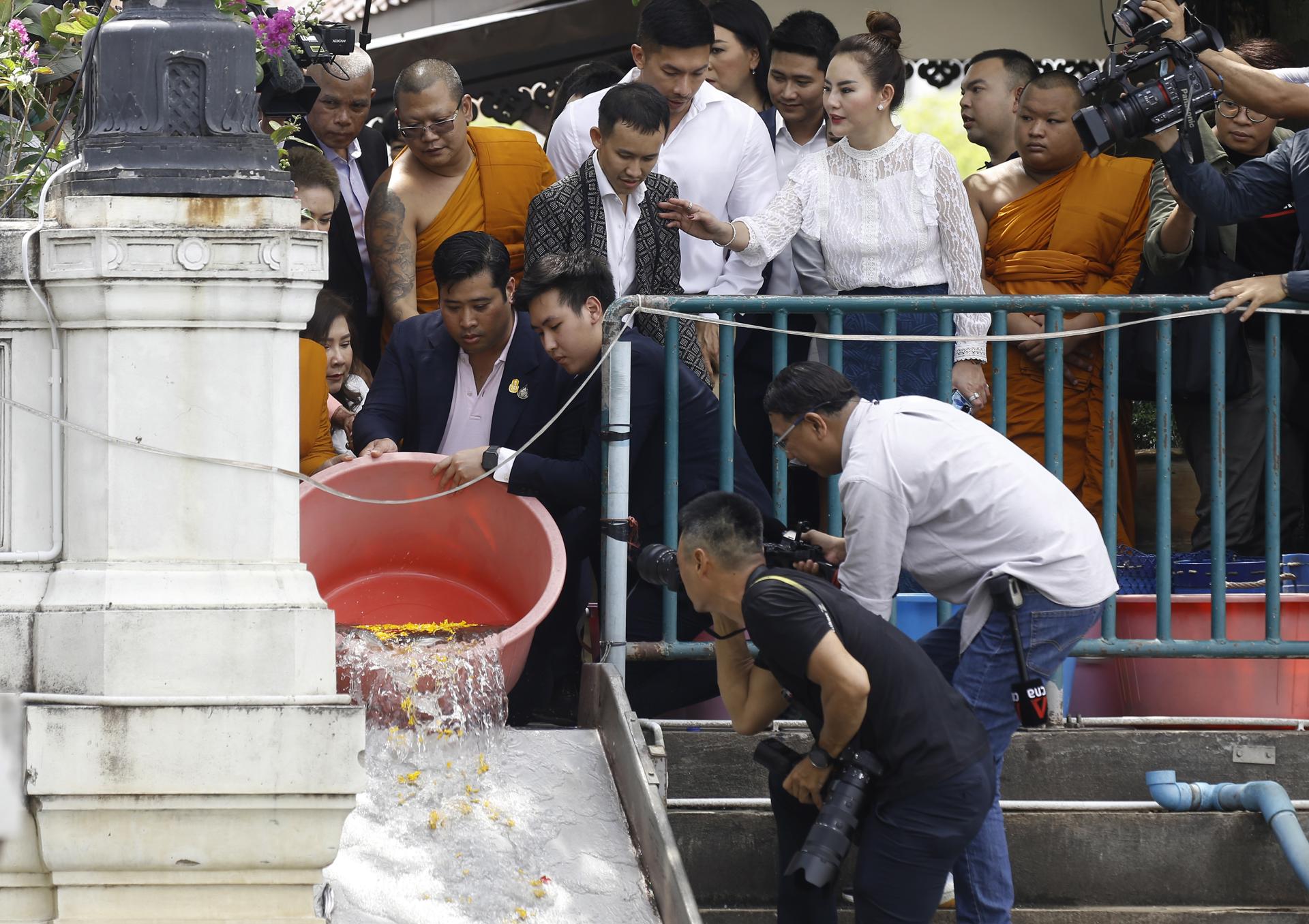 Thai King's second son Vacharaesorn Vivacharawongse (L) releases fishs to make merit as he visits at Wat Yannawa temple in Bangkok, Thailand, 10 August 2023. EFE-EPA/NARONG SANGNAK
